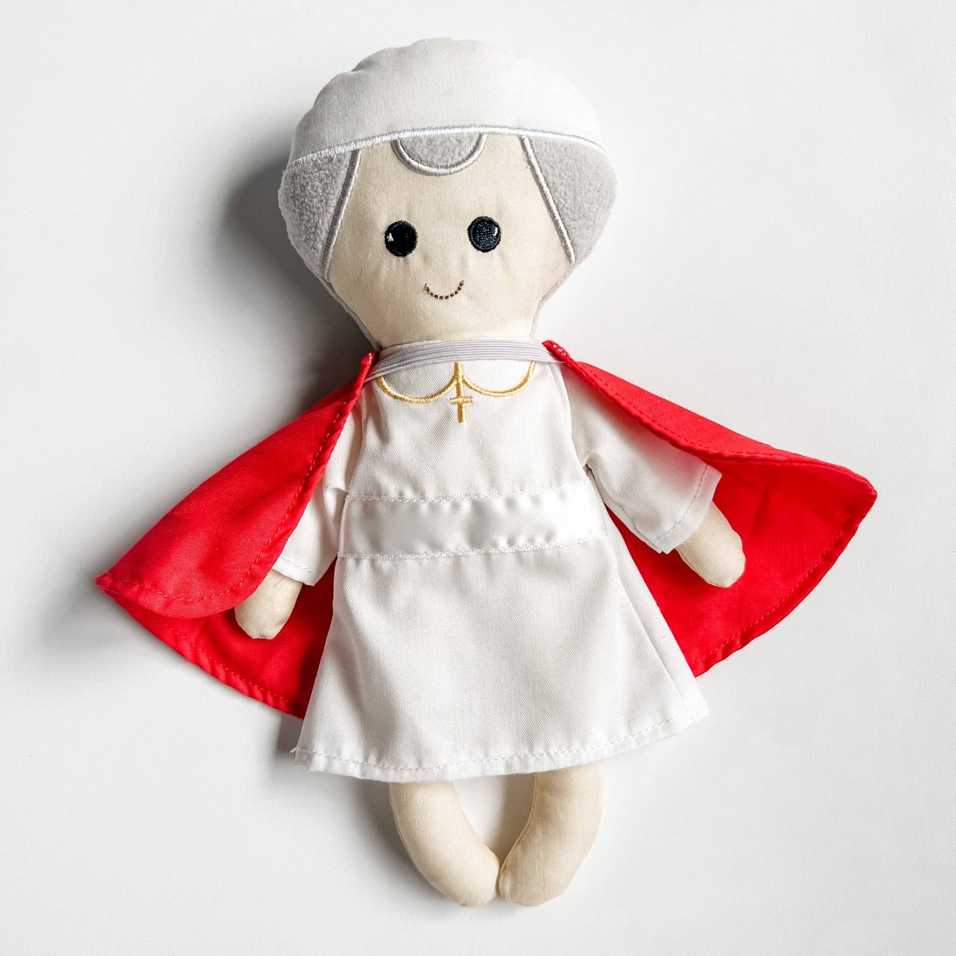 Toy figure with a red cape and white outfit on a light gray background