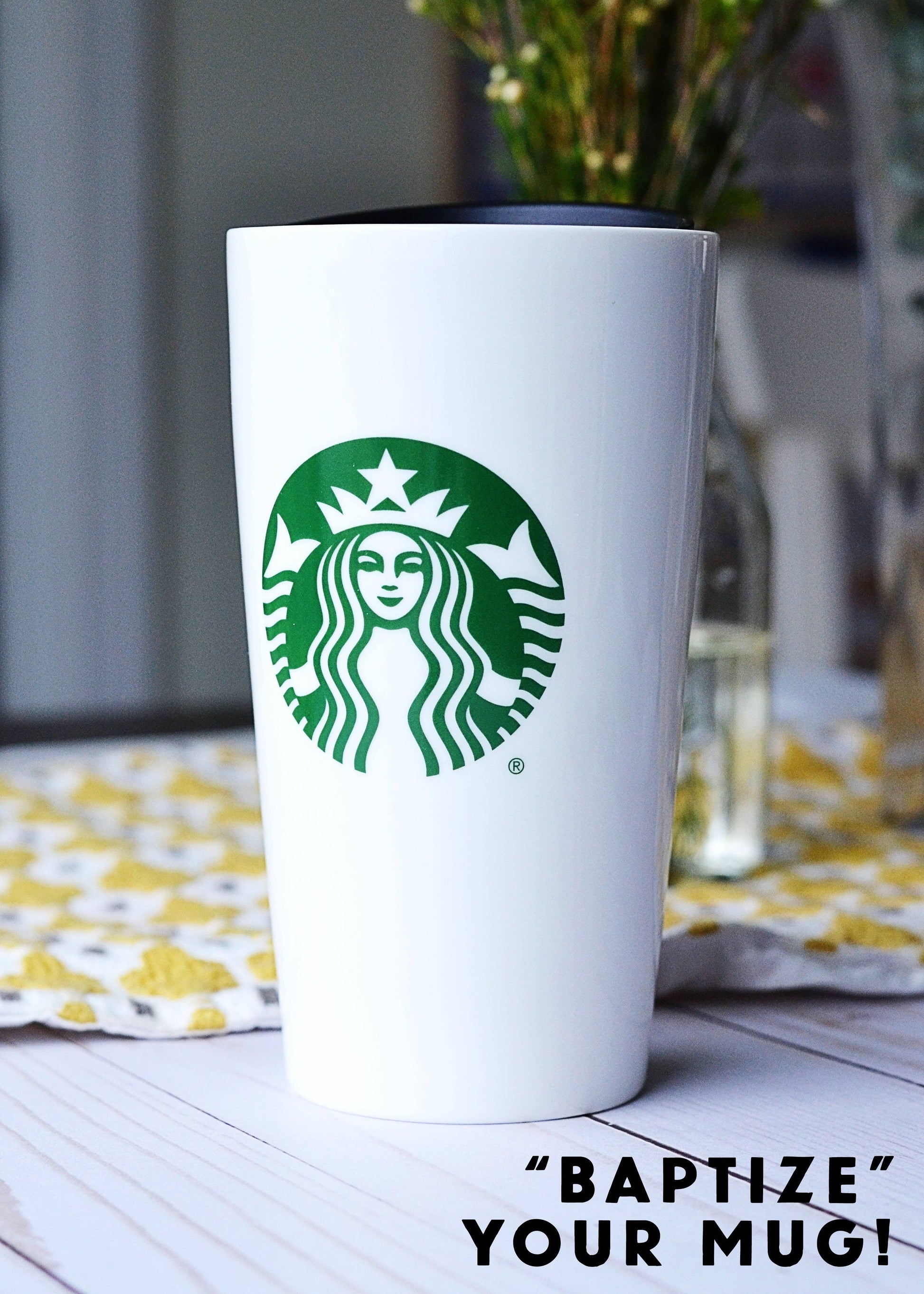 White Starbucks tumbler with green logo on a table with a blurred background