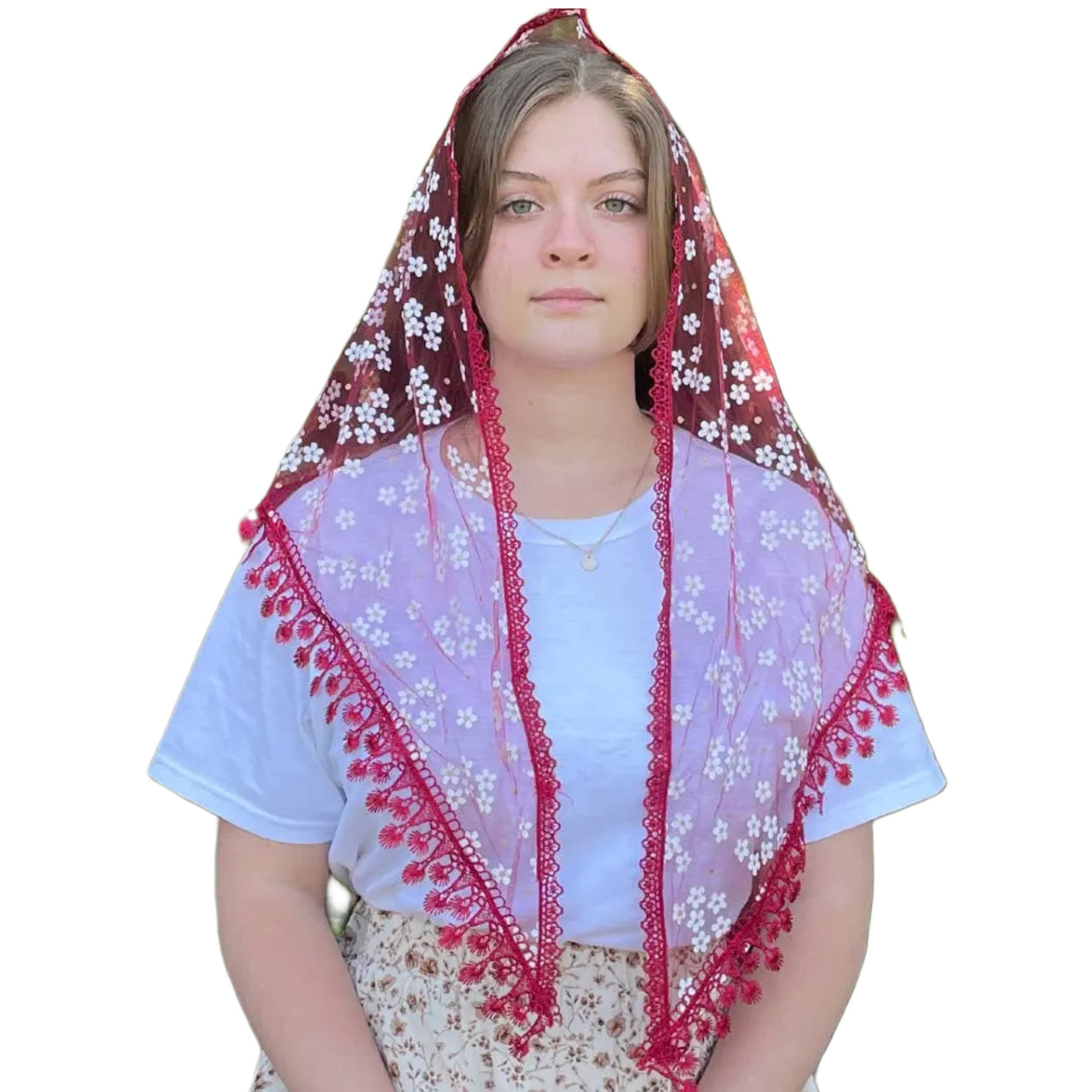 Woman wearing a floral veil with red trim on a white background