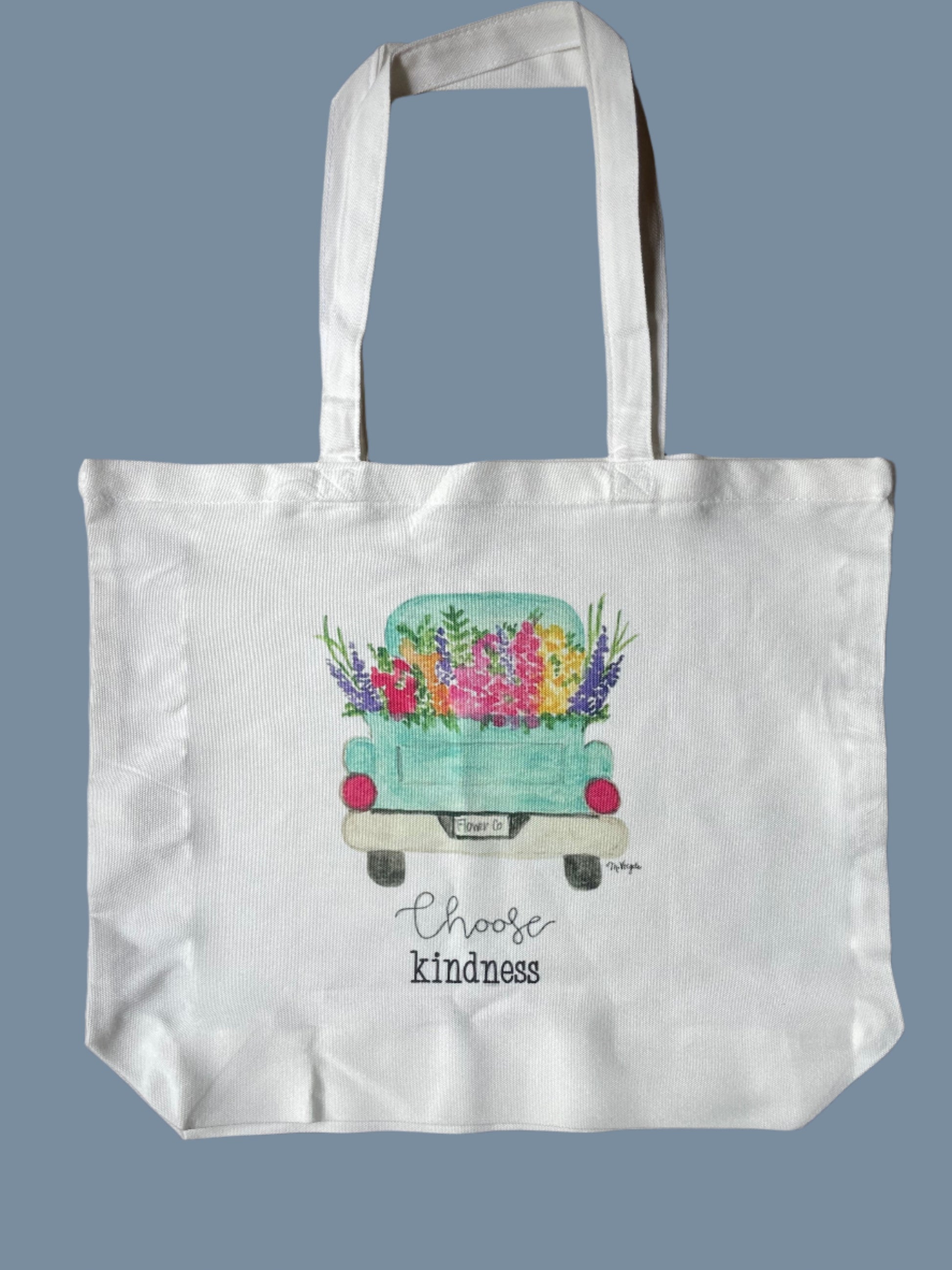 White tote bag with a colorful design and text on a blue background
