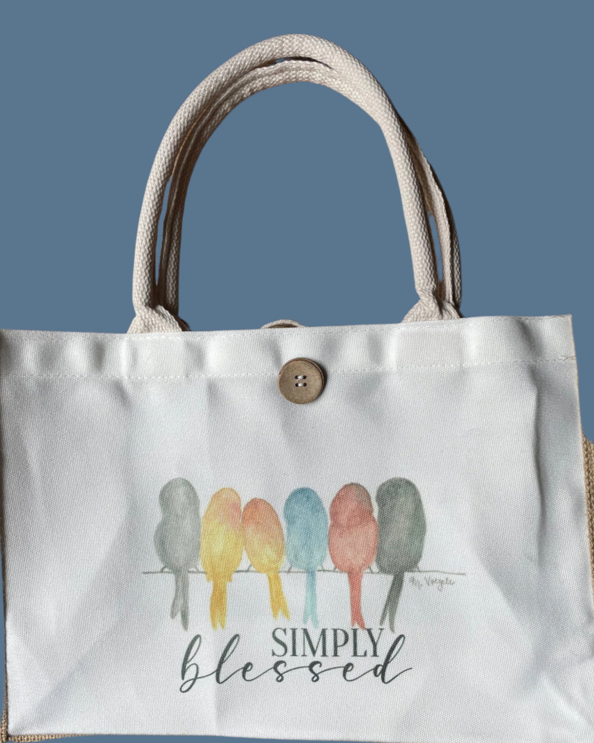Tote bag with 'Simply Blessed' text and colorful design on a blue background