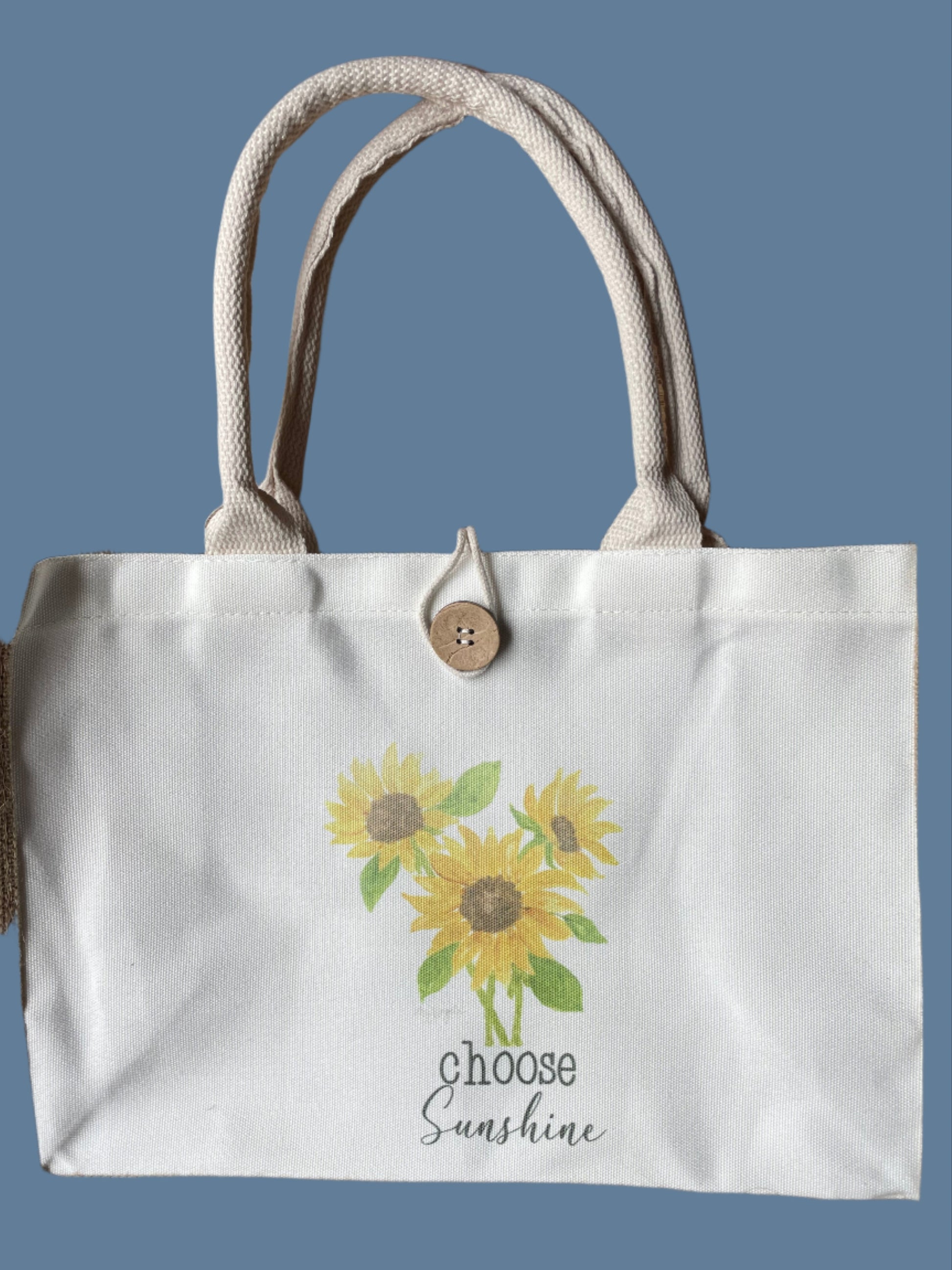 Tote bag with sunflower design and text on a blue background