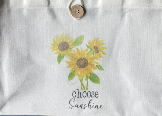 Tote bag with sunflower design and text on a blue background