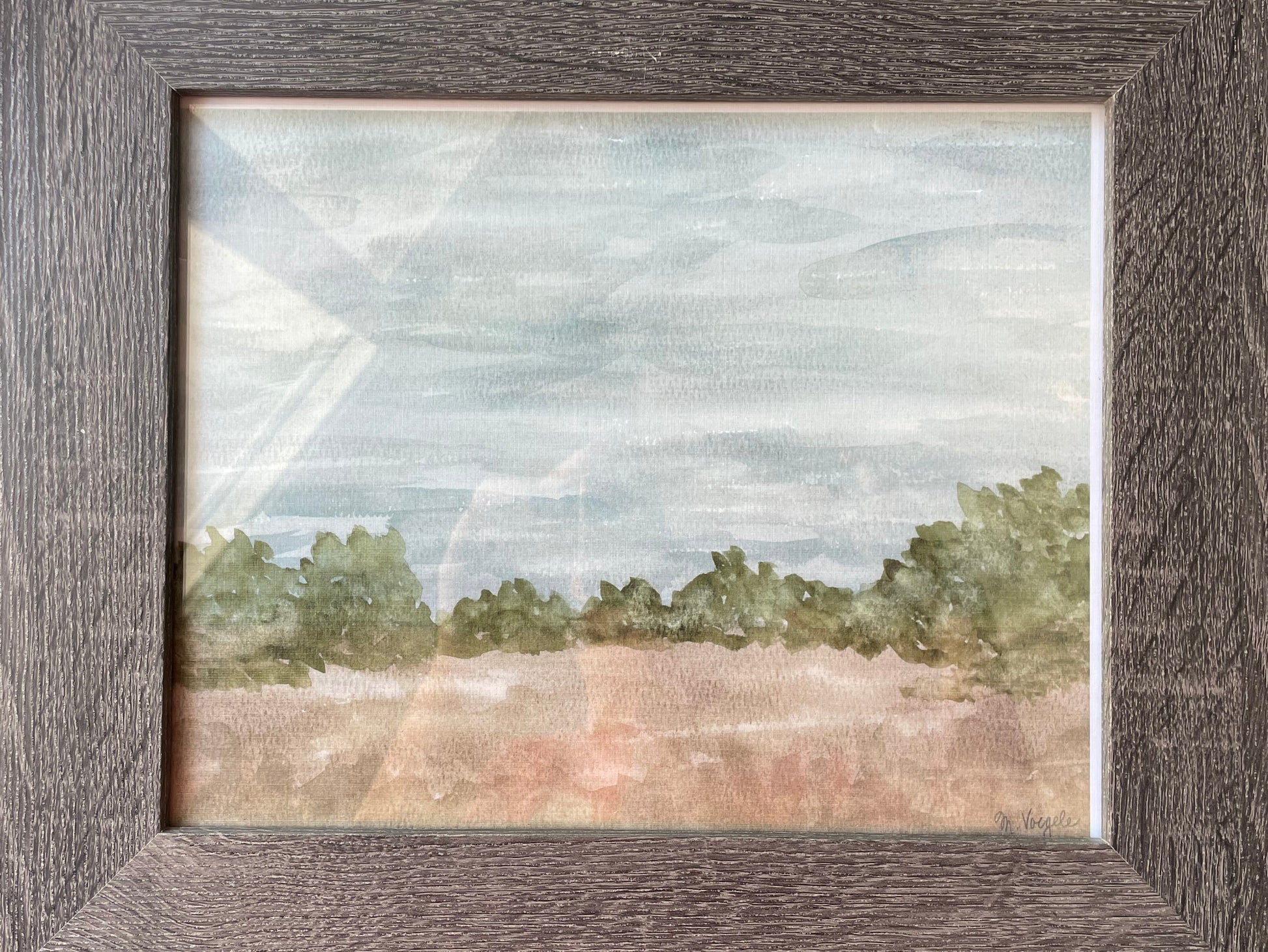 Framed landscape painting with trees and sky.
