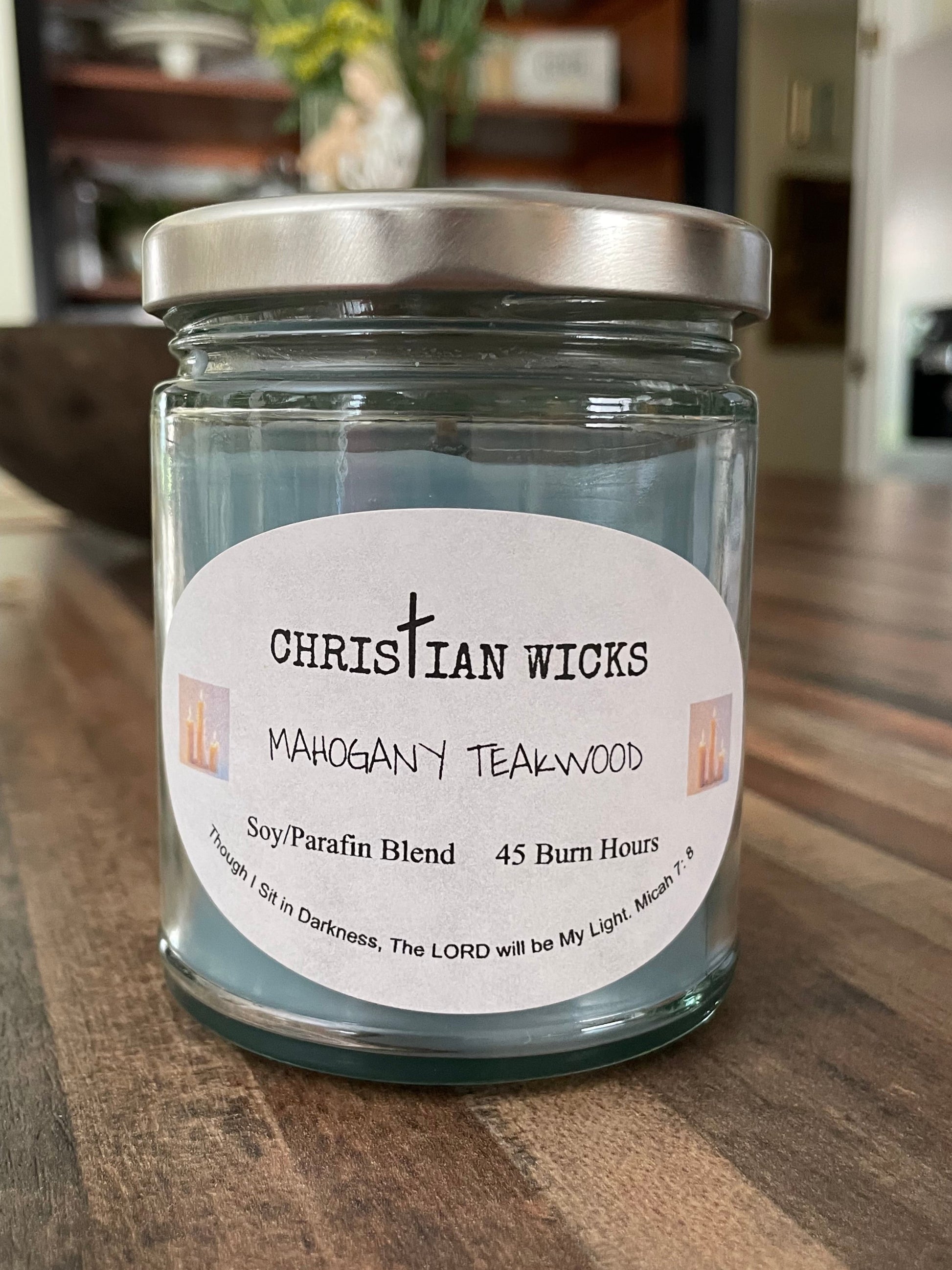 Jar of candle with a label on a wooden surface