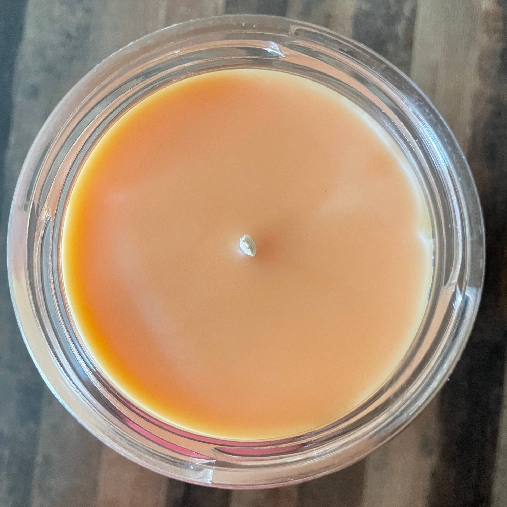 Beige candle on a wooden surface