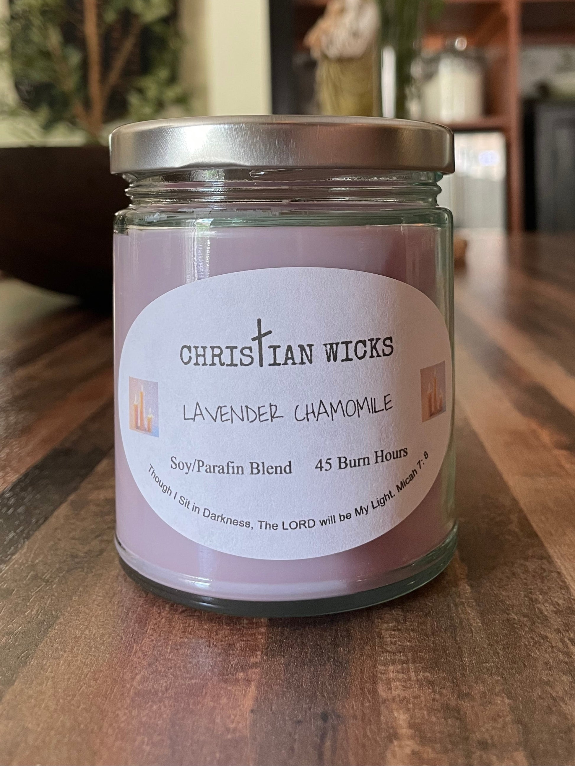 Jar of Christian Wicks lavender candle on a wooden surface with a blurred background