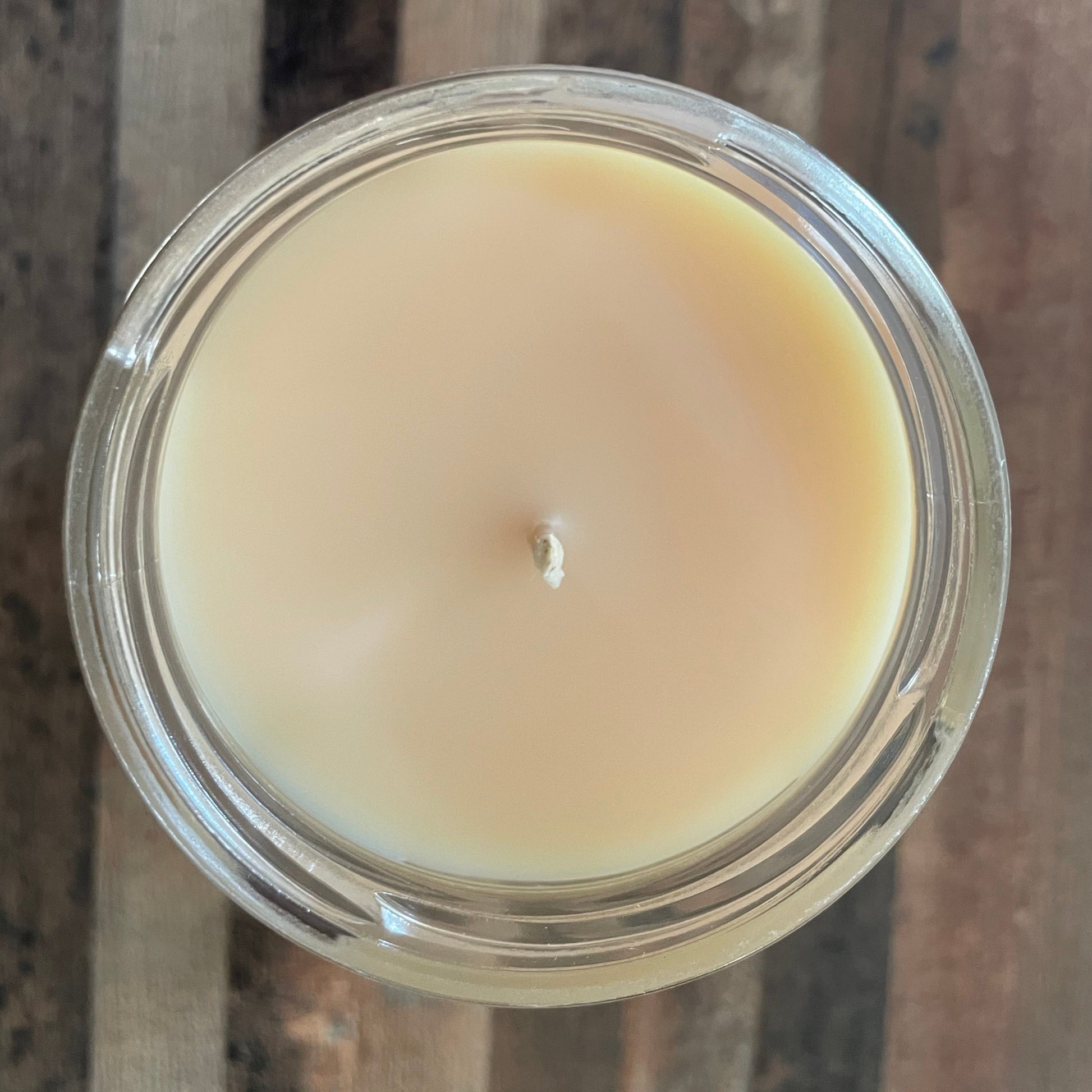 Candle in a glass jar on a wooden surface
