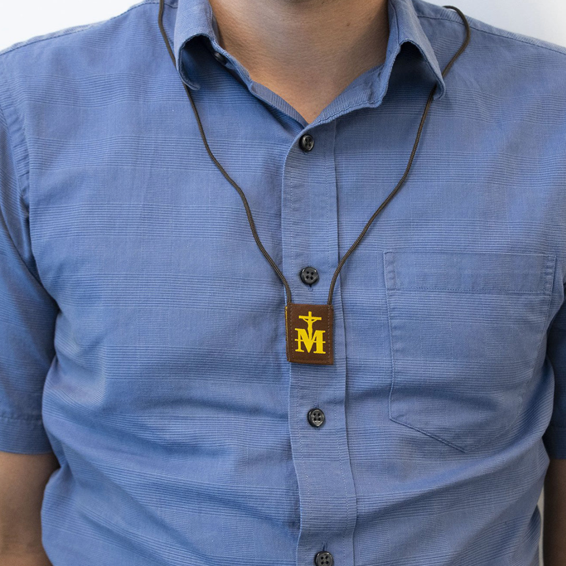 Person wearing a blue shirt with a brown scapular