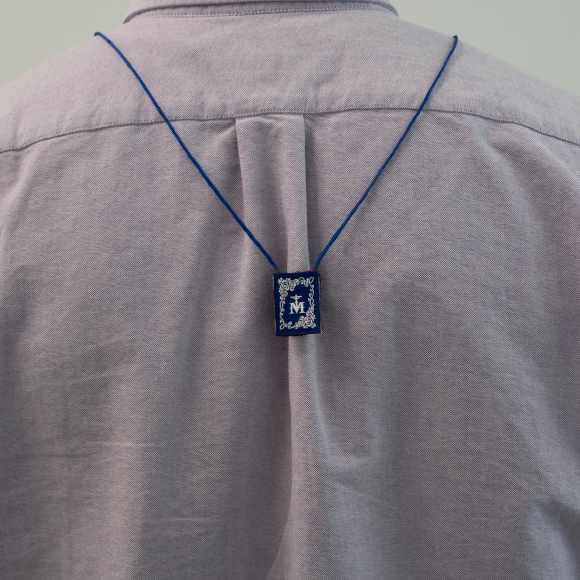 Gray shirt with a blue scapular on a plain background
