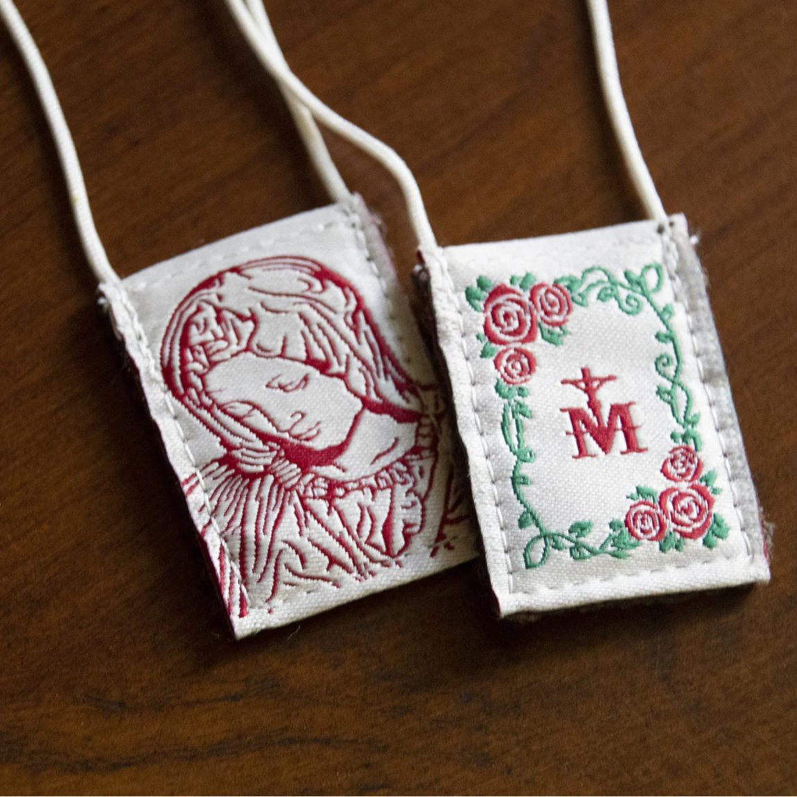 Scapular with Our Lady and the Marian symbol on a wooden surface