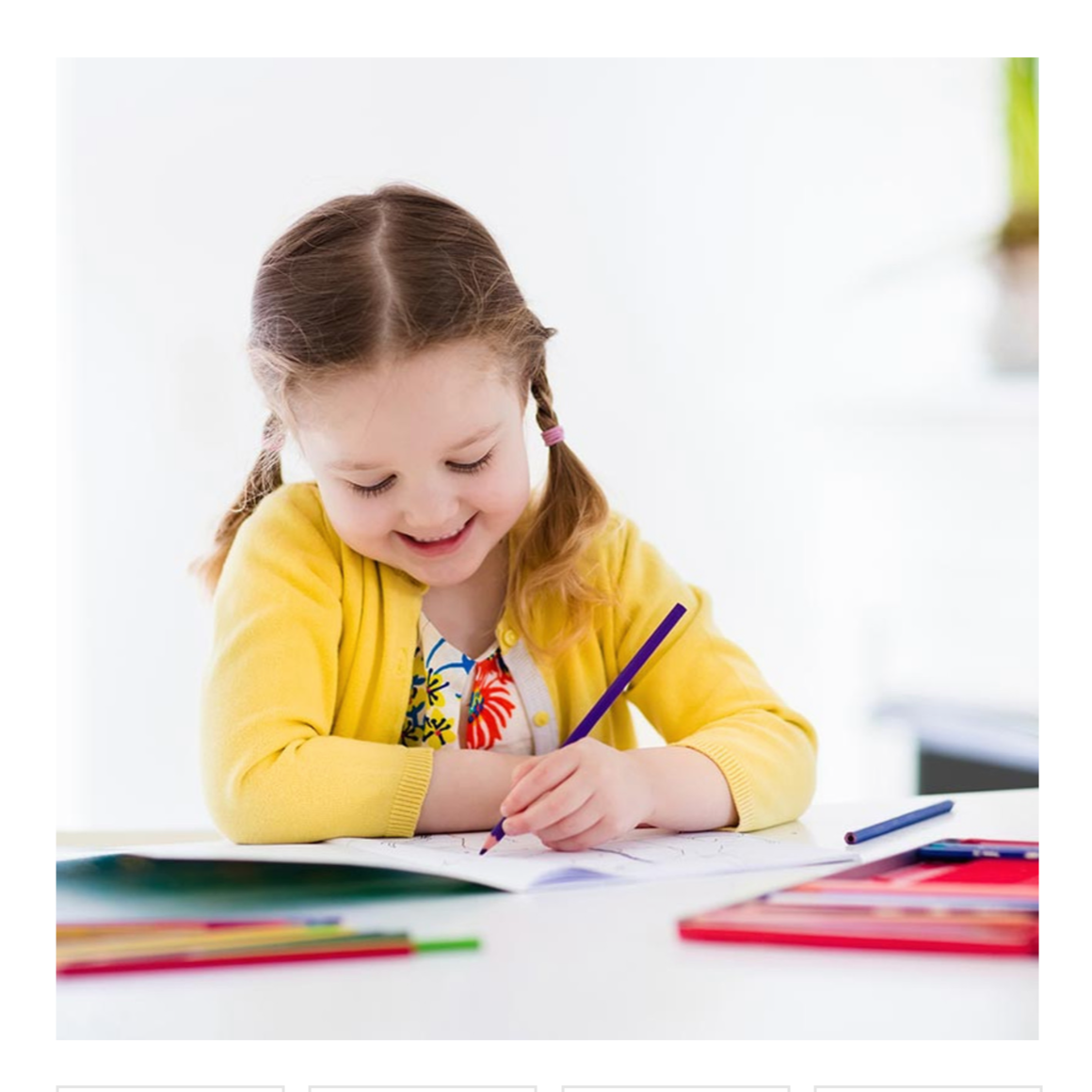 Child in a yellow sweater coloring with crayons on a white background
