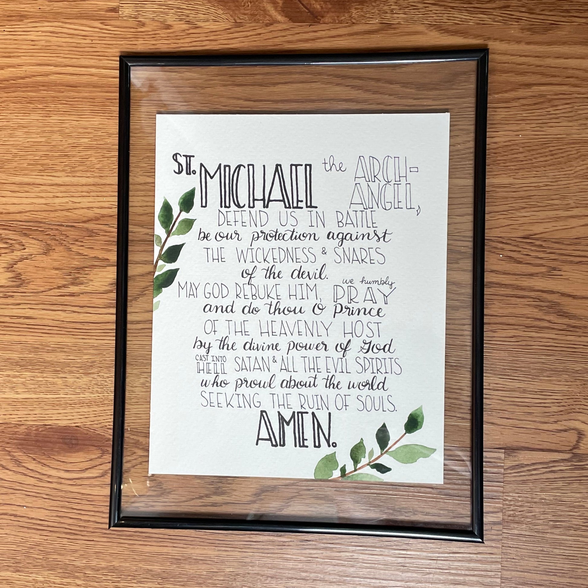 Framed print with text and leaves on a wooden floor