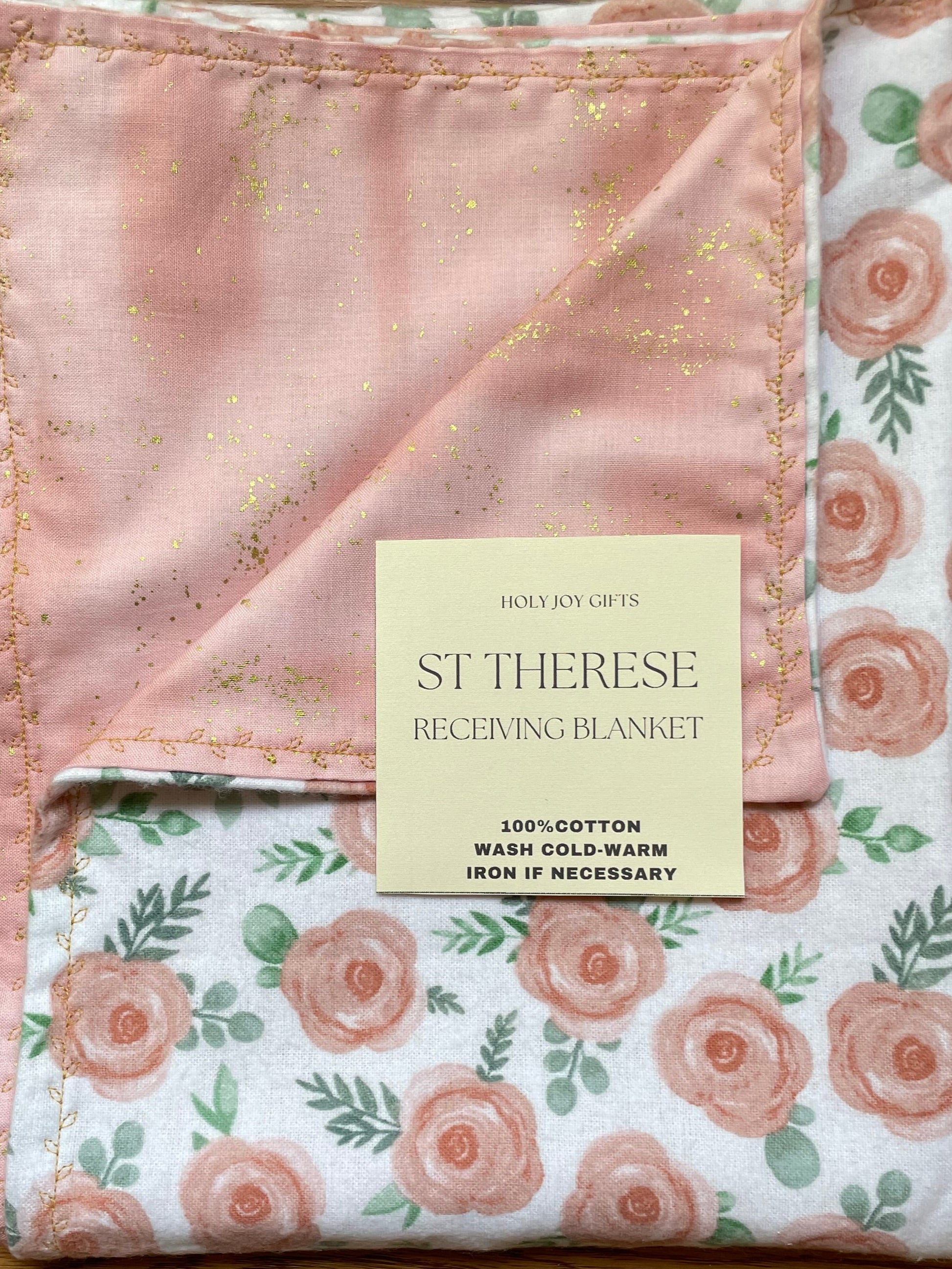 Reversible baby blanket with floral pattern on one side and pink and gold fabric on the reverse