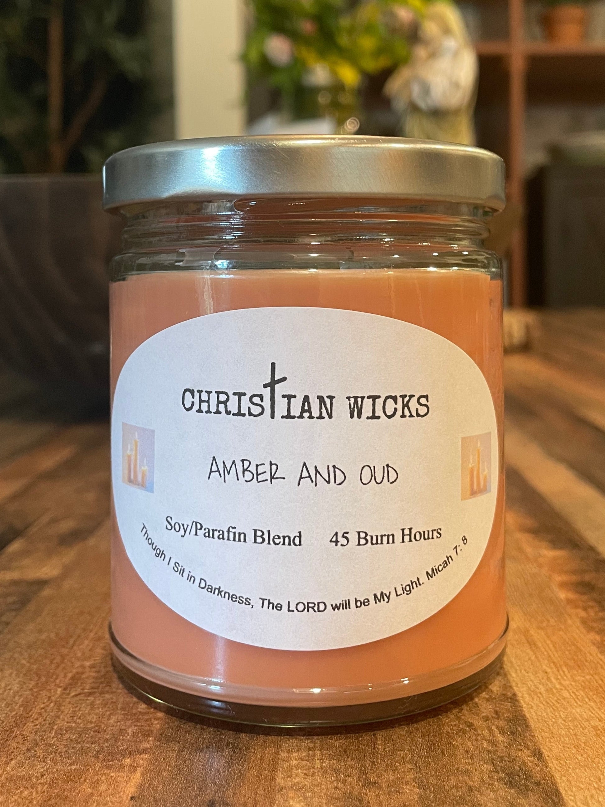 Jar of Amber & Out product on a wooden surface with a blurred indoor background