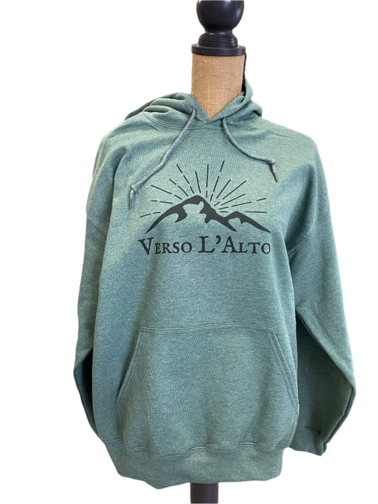 Green hoodie with a logo and text on a table in a room setting