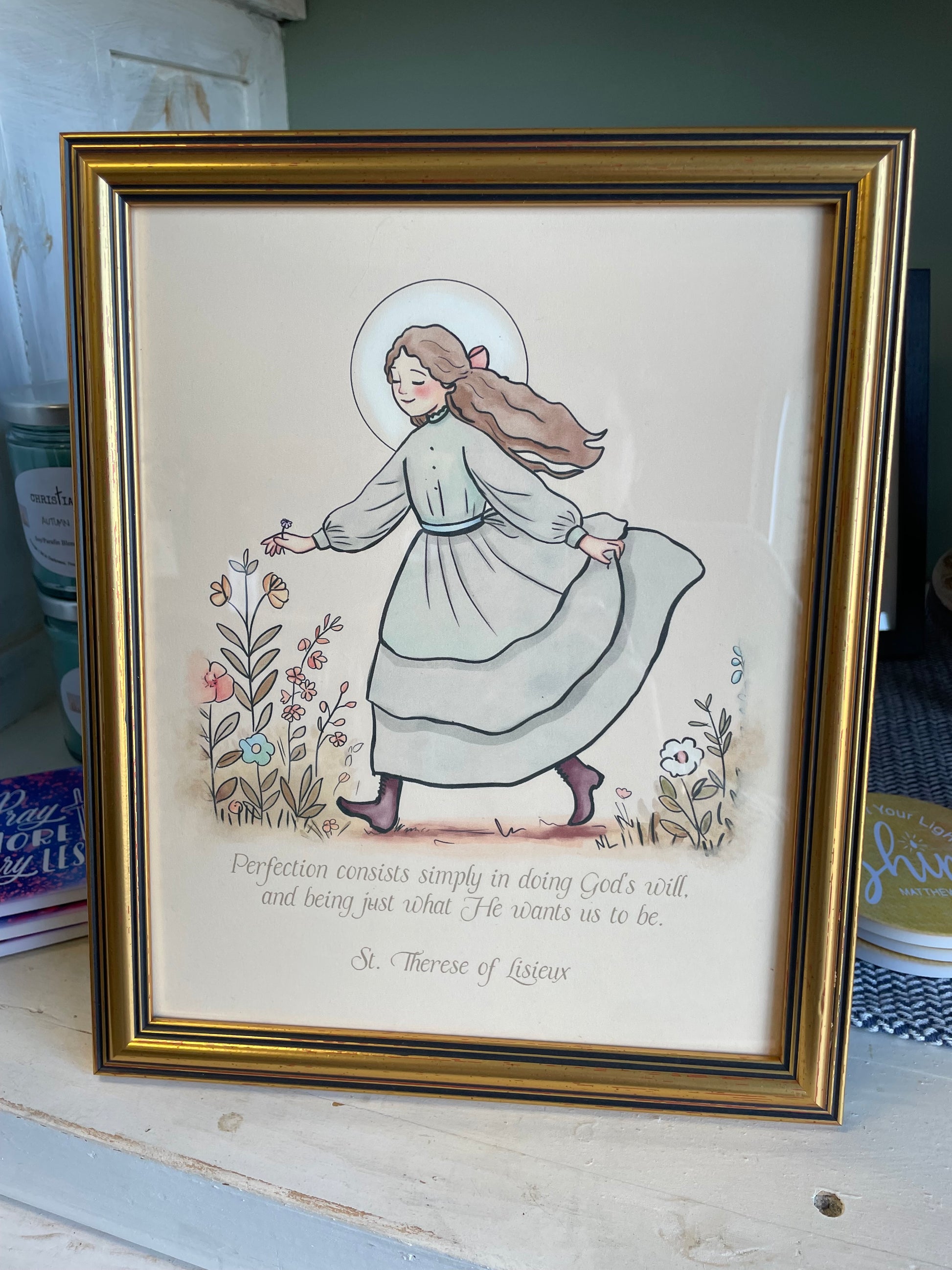 Framed artwork of a woman with a child, surrounded by text and floral elements.