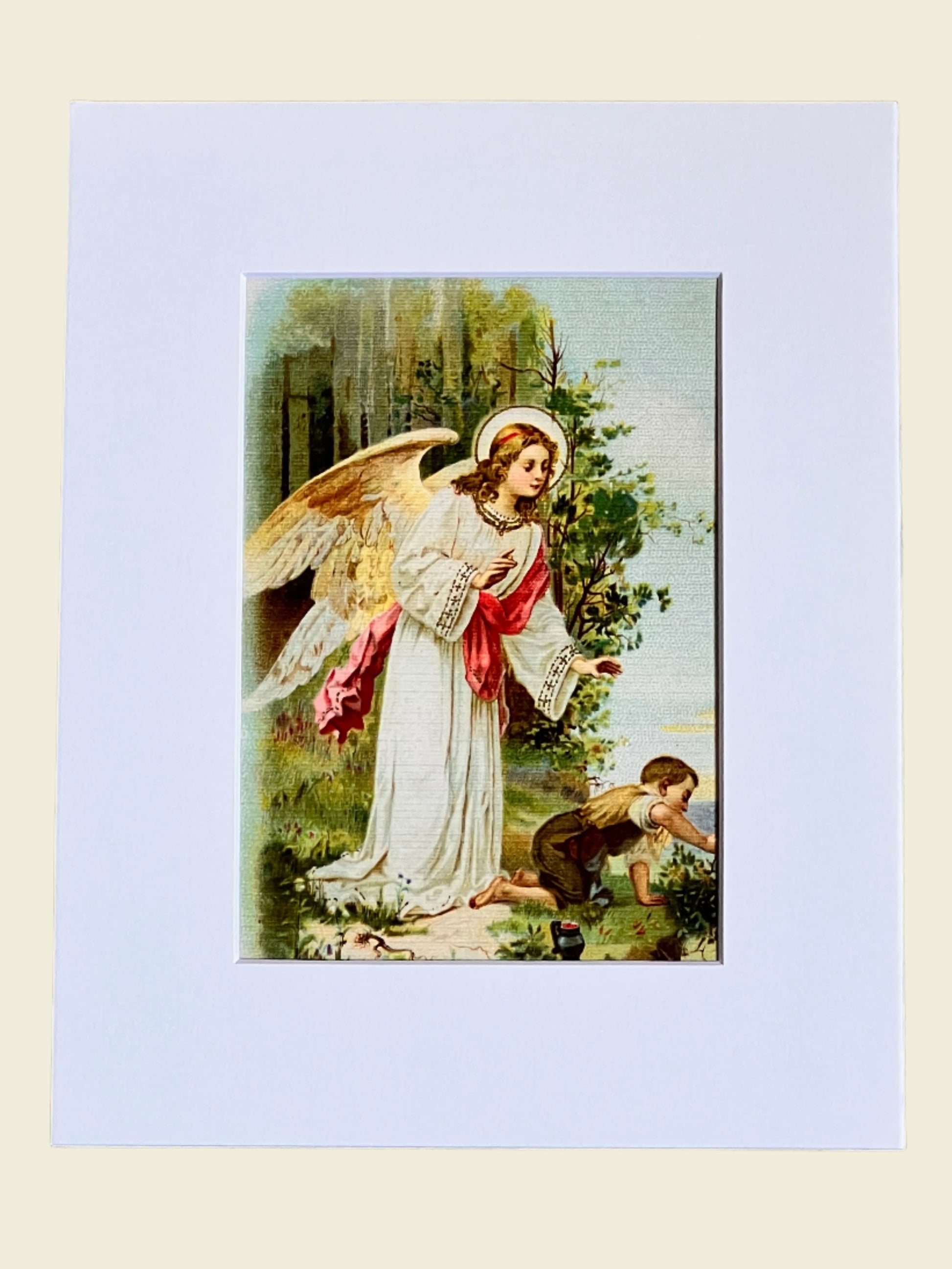 Matted artwork of an angel with a child in a natural setting