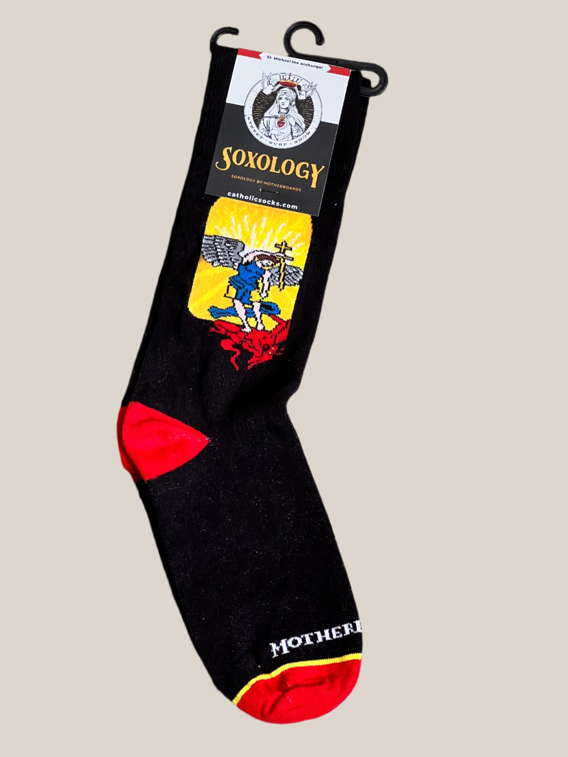 Black sock with colorful design and 'Soxology' branding on a beige background