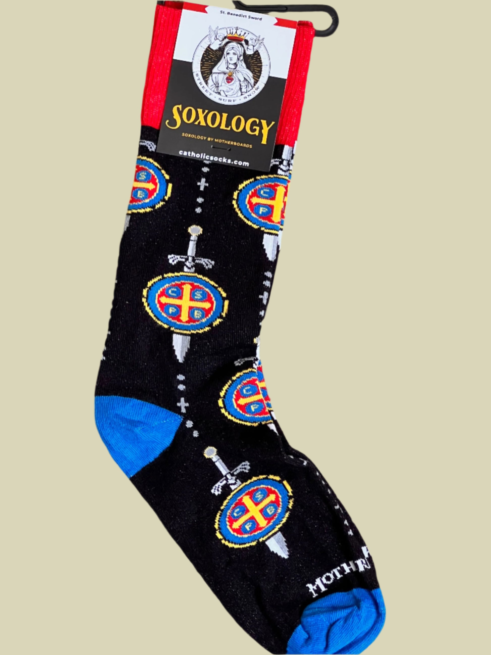 Black sock with colorful designs and blue toes, displayed on a beige background with 'soxology' branding.