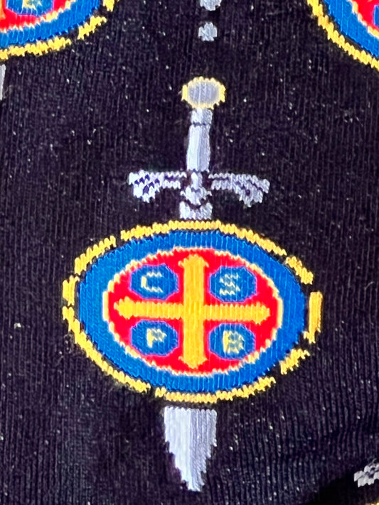 Embroidered patch with a cross and sword on a dark background
