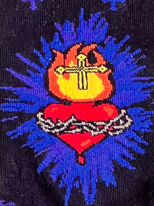 Embroidered design of a red heart with a cross on a black background