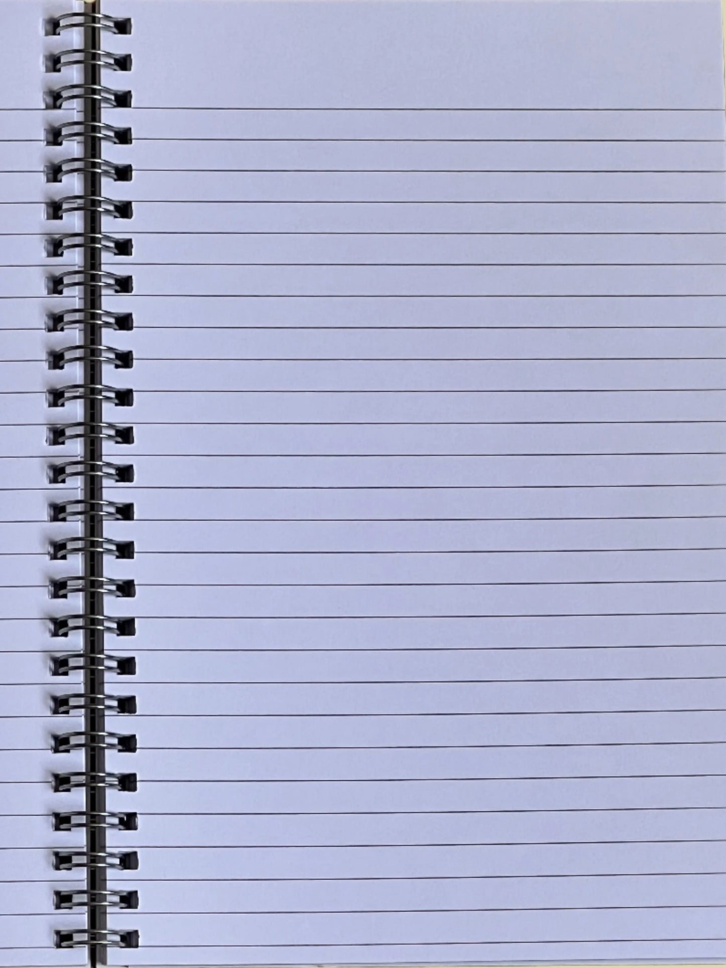 Close-up of a spiral-bound notebook with lined pages on a light blue background