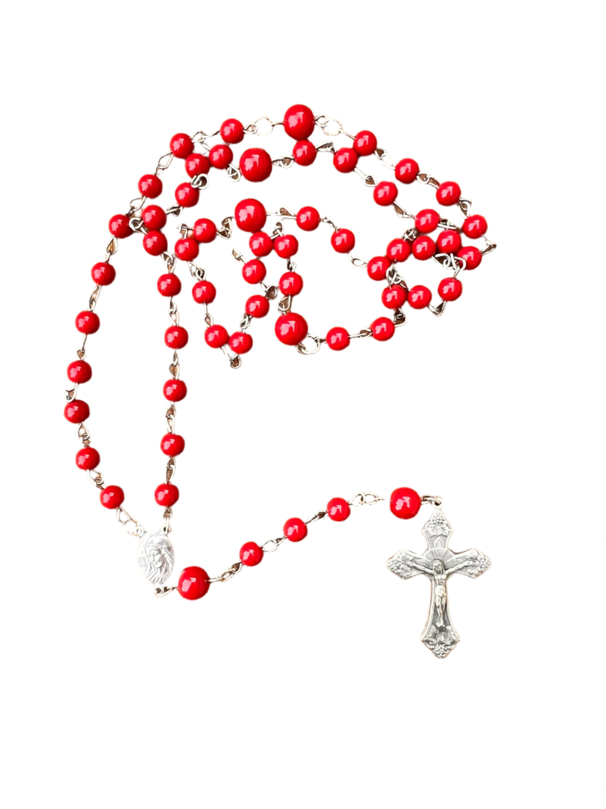 Red rosary with silver cross on a wooden surface