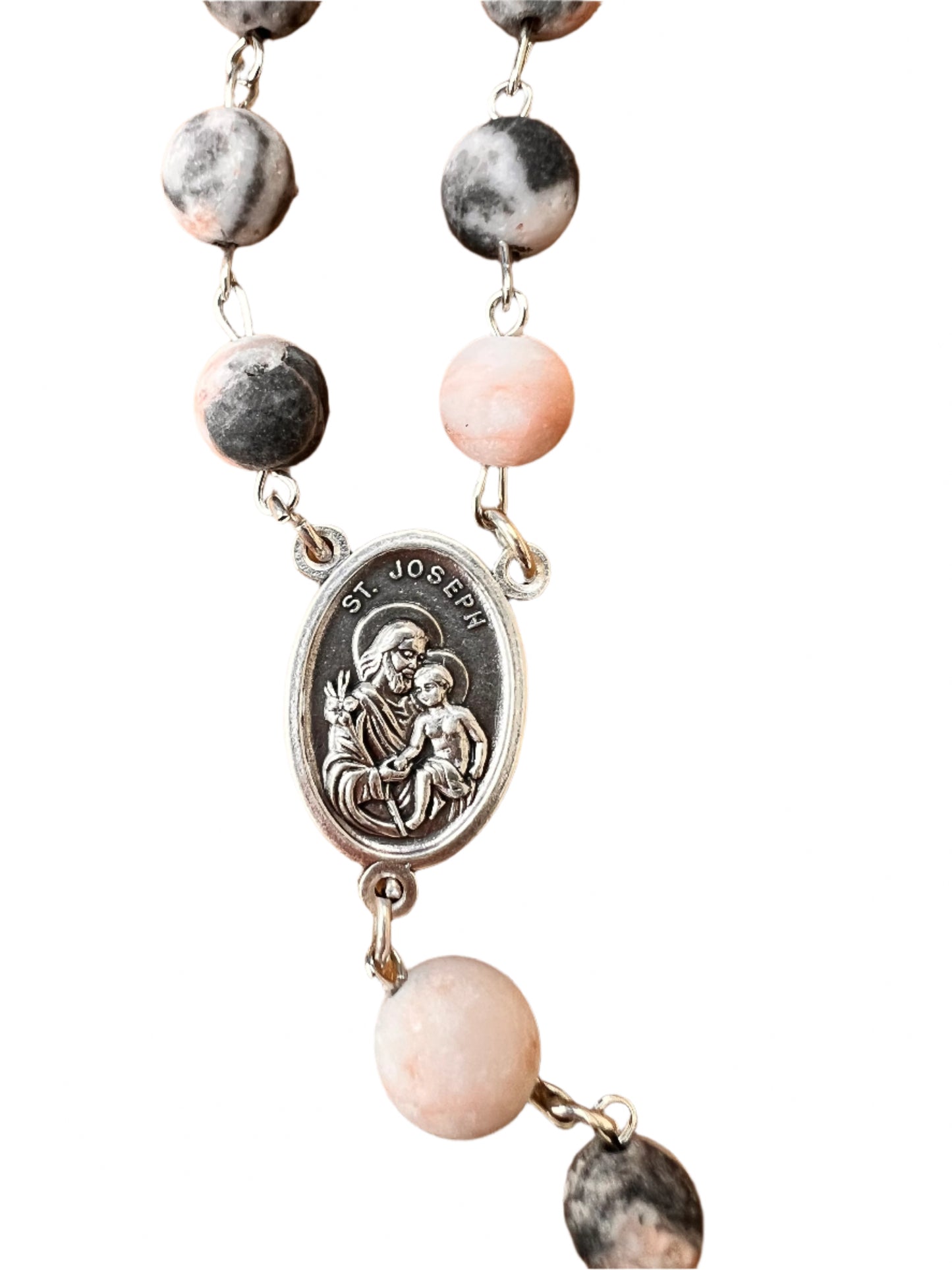 Necklace with pink and gray beads on a wooden surface