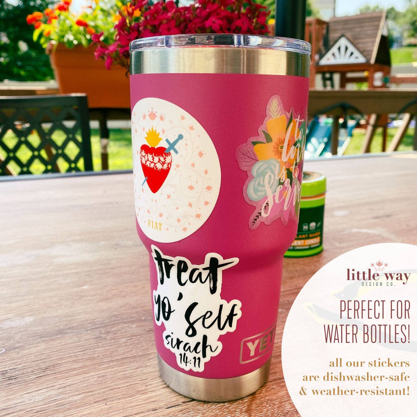 Pink tumbler with stickers on a wooden table outdoors