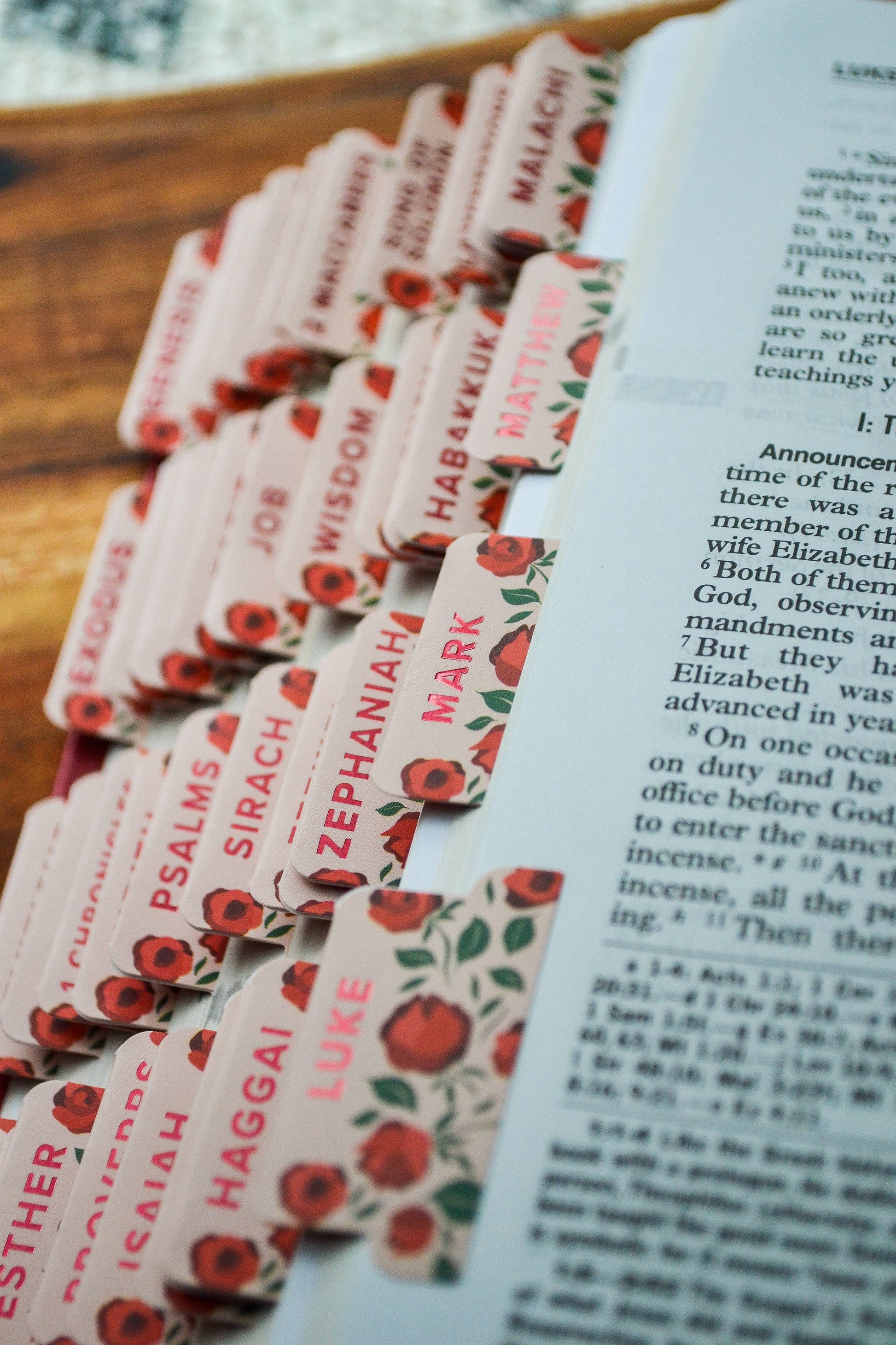 Set of religious bookmarks with red floral design on a book page.