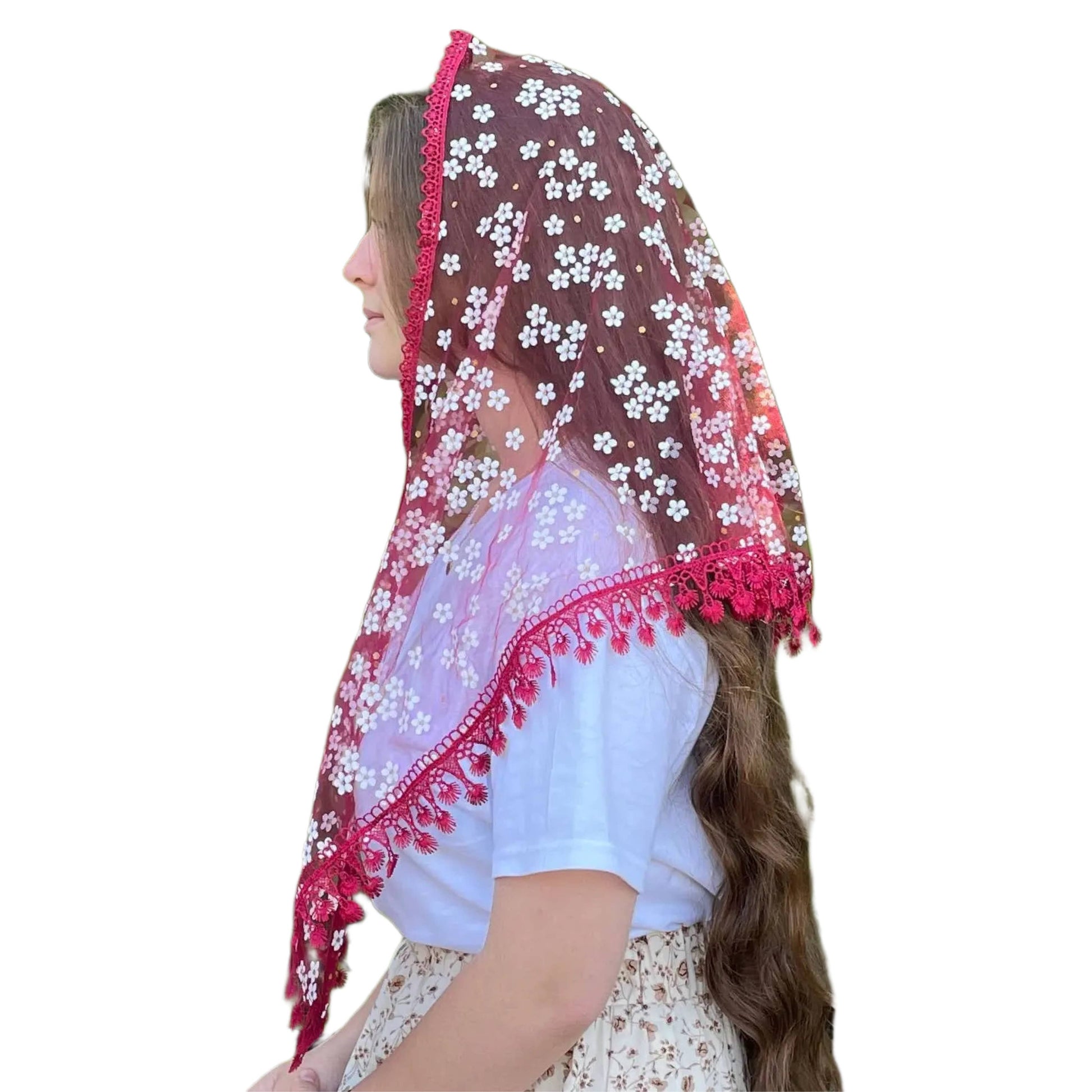 Woman wearing a floral veil with pink trim on a white background