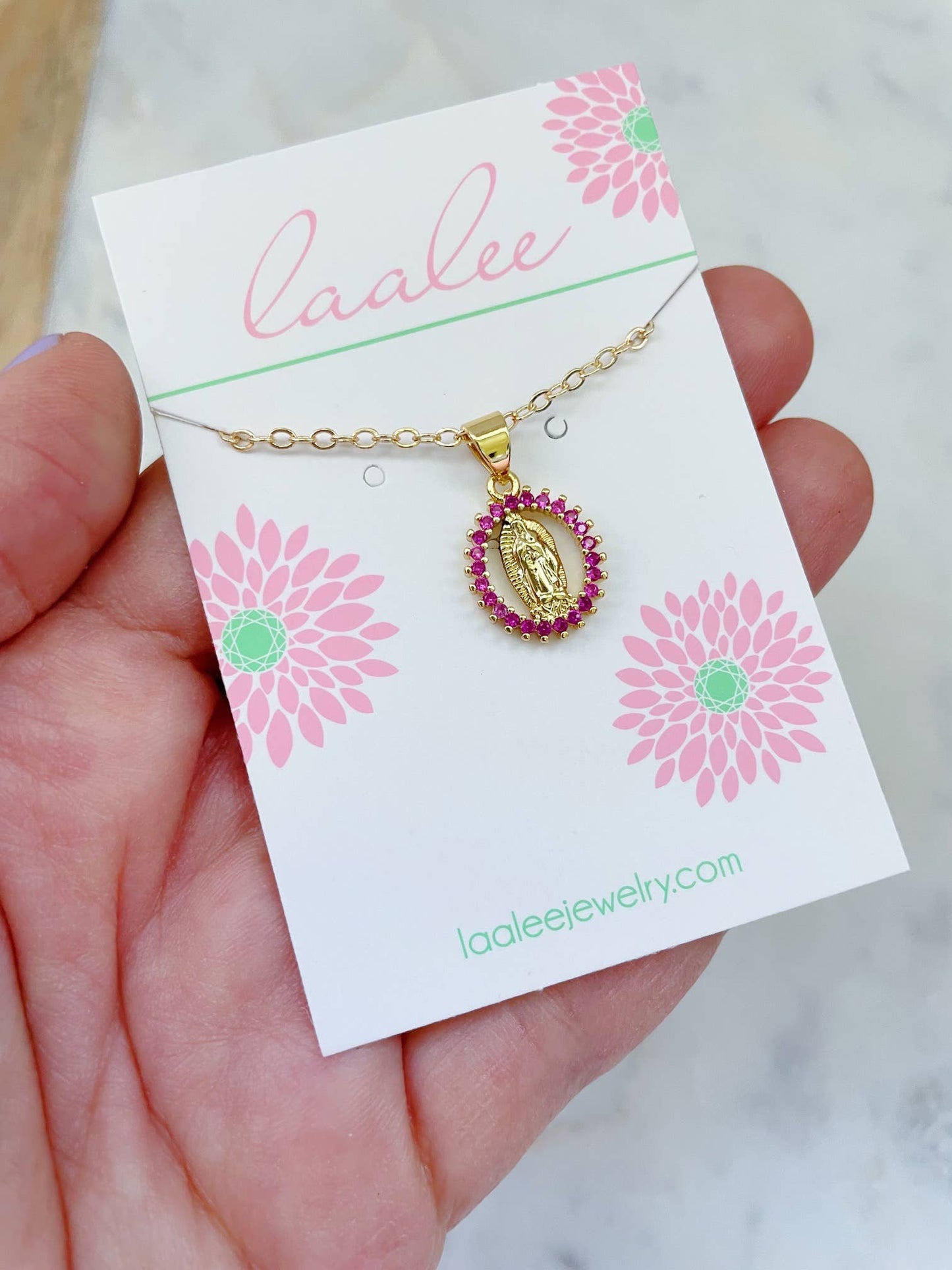 Gold necklace with a pink pendant on a Laalee jewelry card.