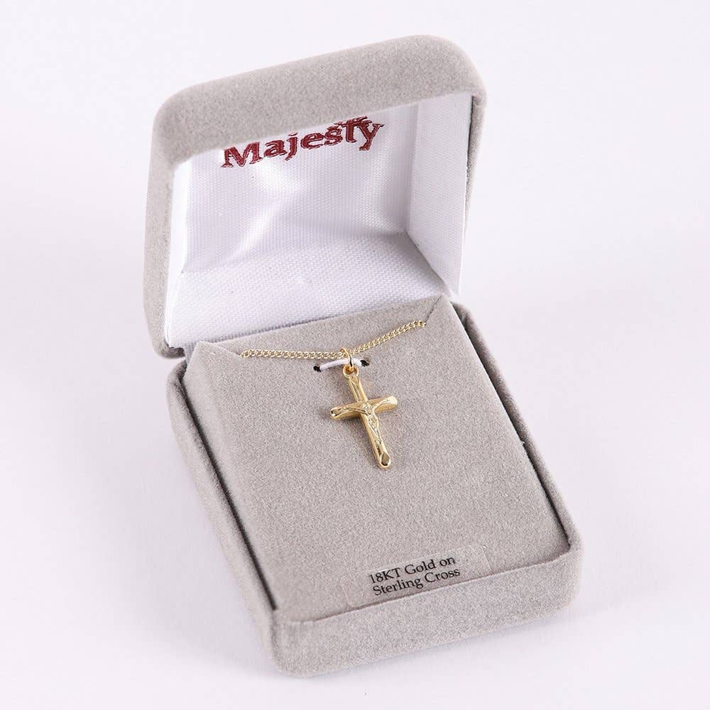 Gold cross necklace in a 'Majesty' branded jewelry box on a white background