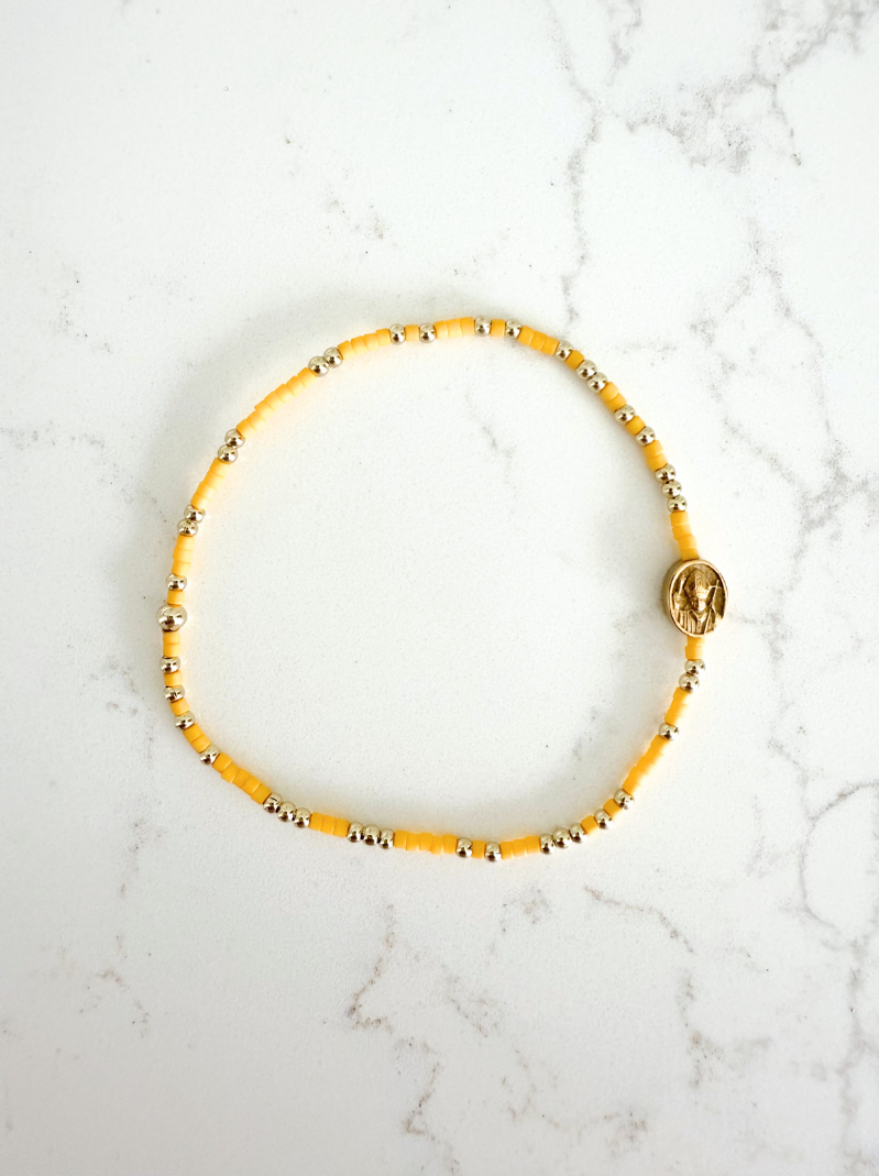 Yellow beaded bracelet on a marble surface