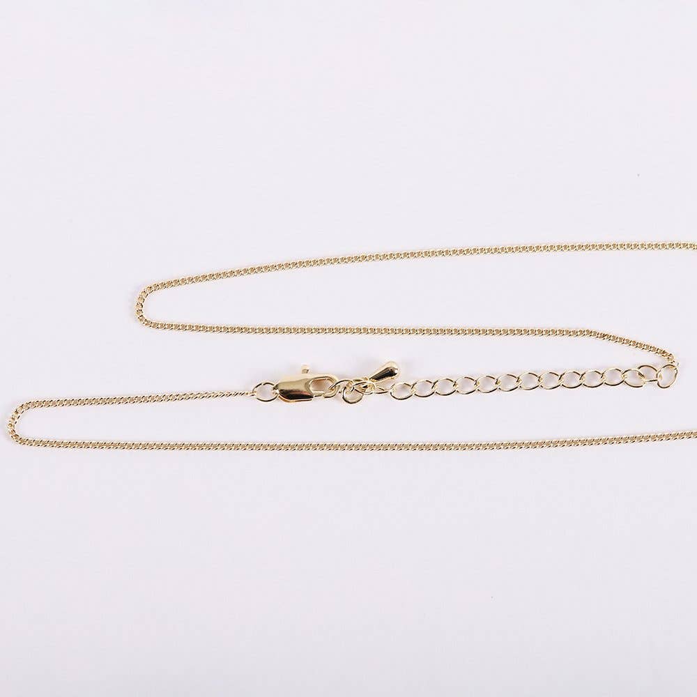 Gold chain necklace on a light gray background