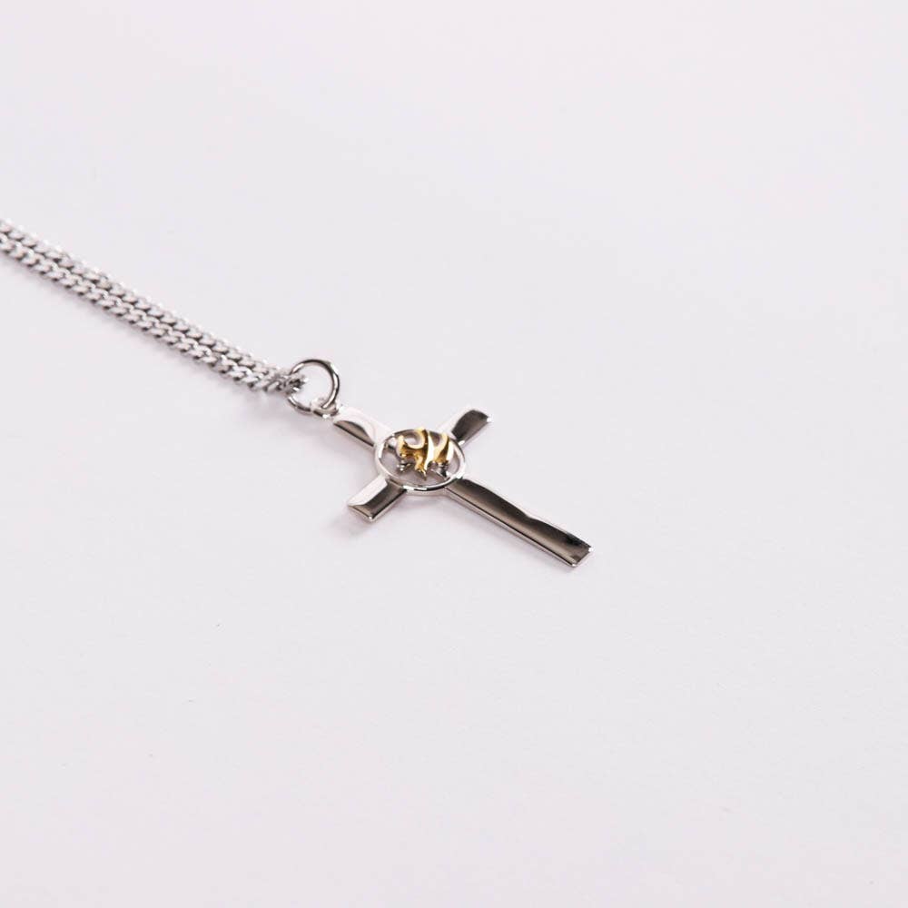 Silver cross necklace with a gold emblem middle on white background 