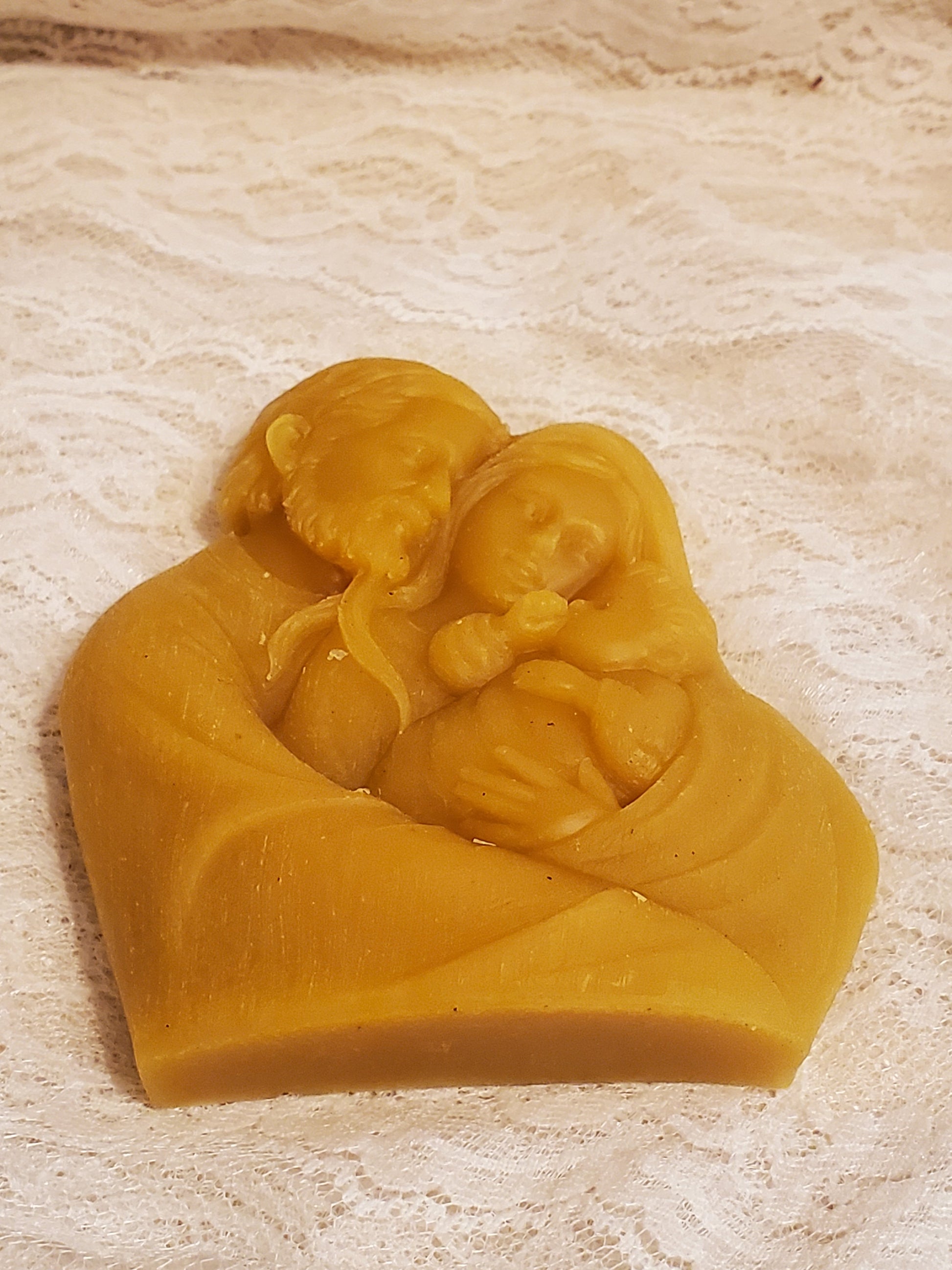 Beeswax design of the Holy Family on a beige background