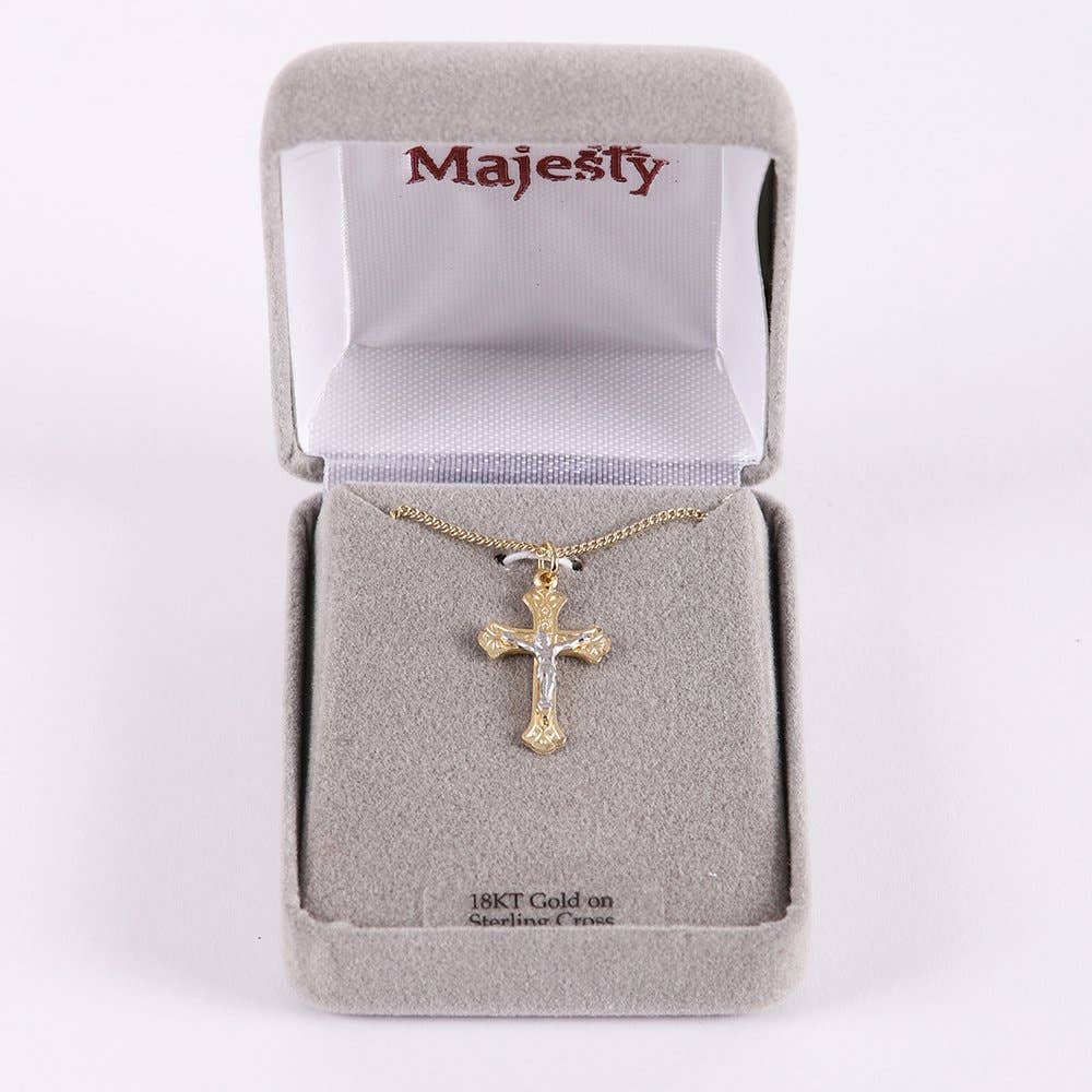 Gold cross necklace in a 'Majesty' branded box on a white background