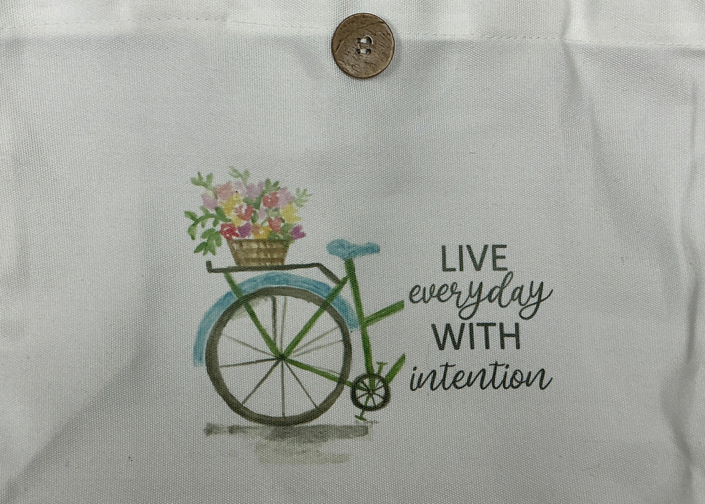 White tote bag with bicycle and flower basket design and text on a white background