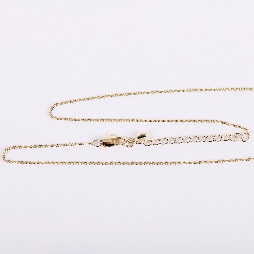 Gold chain necklace on a light gray background