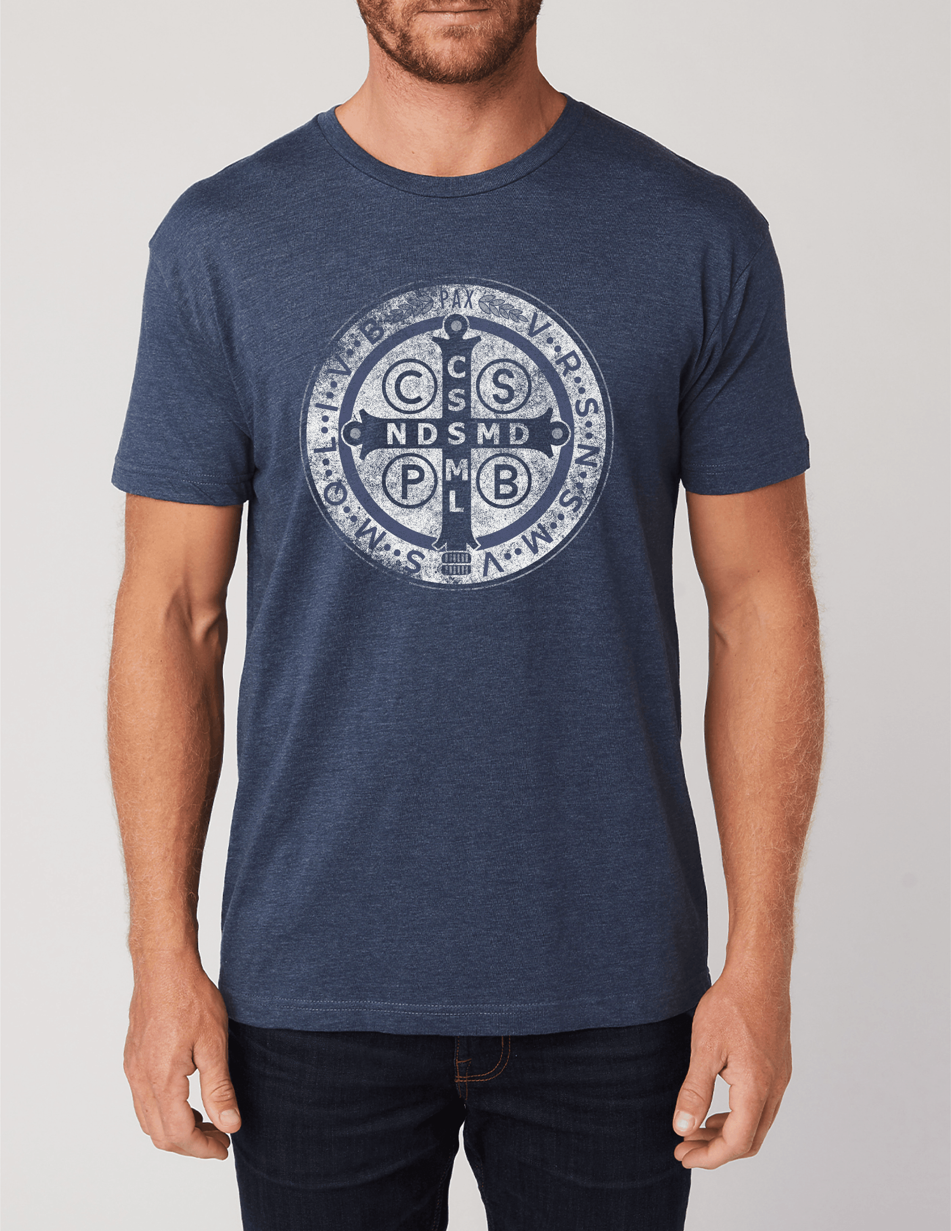 Man wearing a blue t-shirt with a St. Benedict logo on a plain background