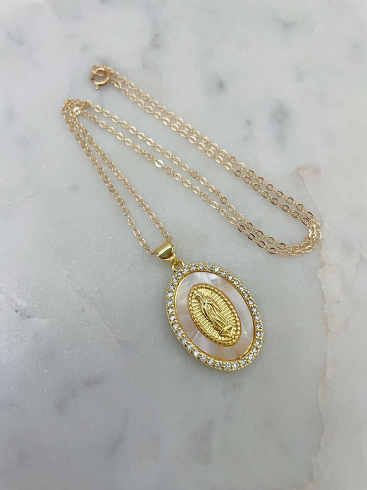 Gold necklace with a pendant on a marble surface