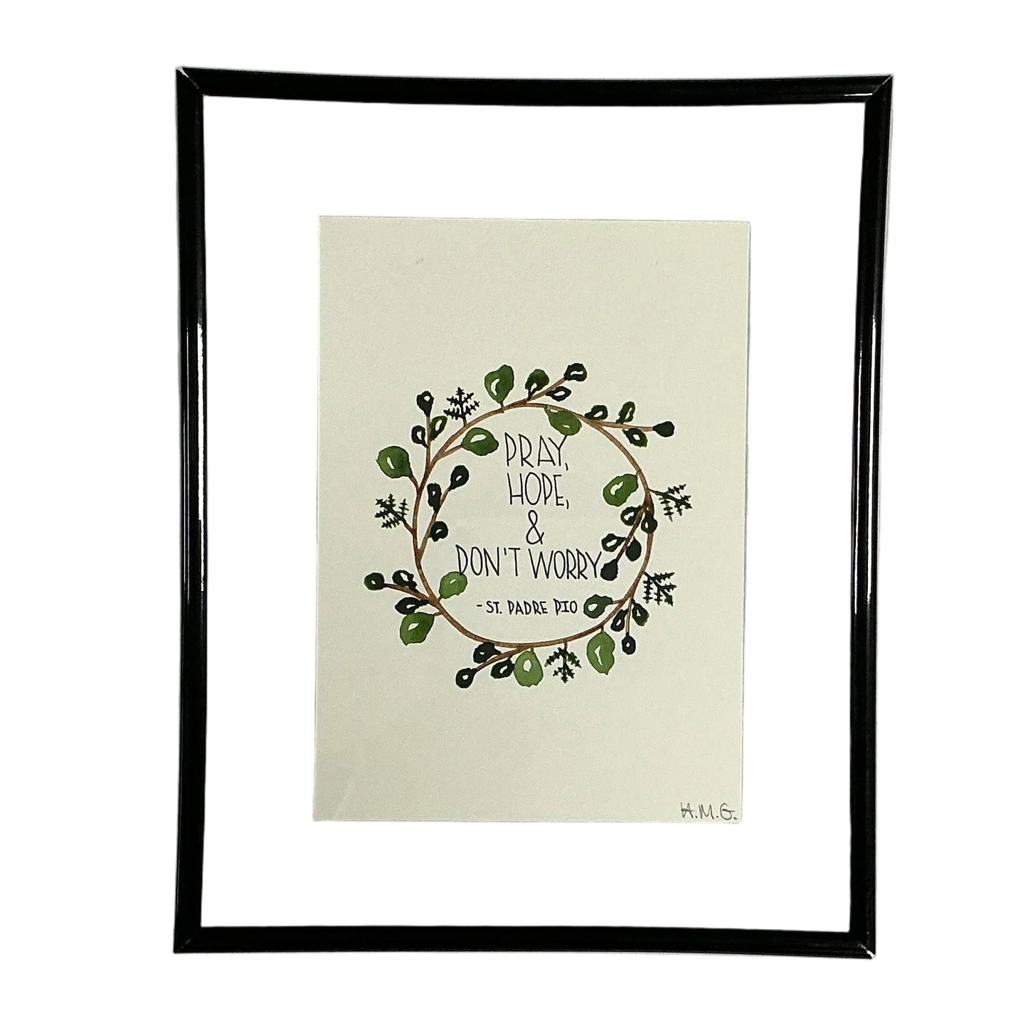 Framed artwork with a wreath design and text on a white background