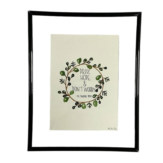 Framed artwork with a wreath design and text on a white background