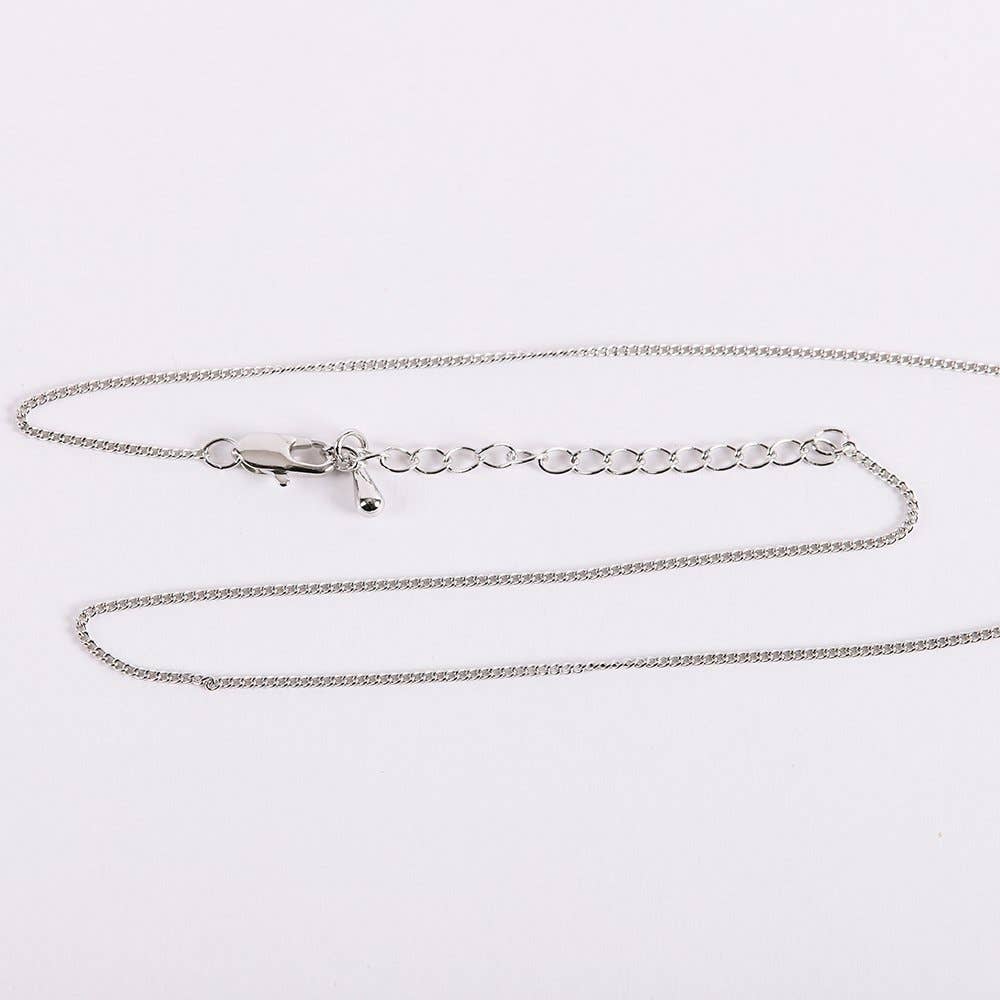 Silver chain necklace on a light gray background