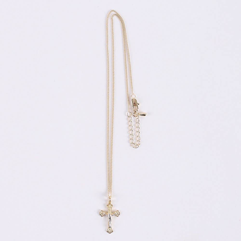 Gold chain necklace with a cross pendant on a light gray background