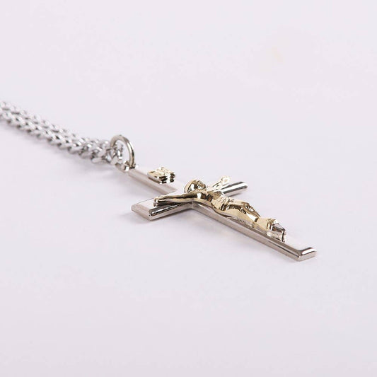 Silver cross pendant with Jesus figure on a white background