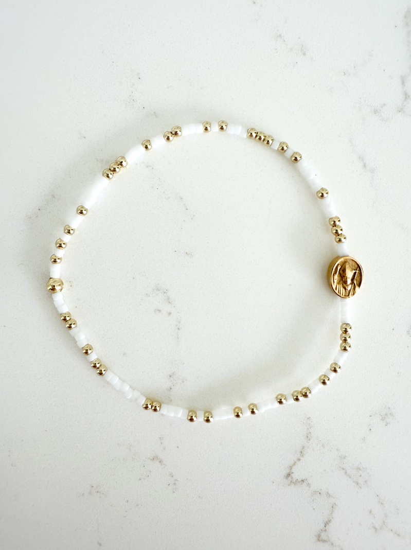 Pearl bracelet with gold beads on a marble surface