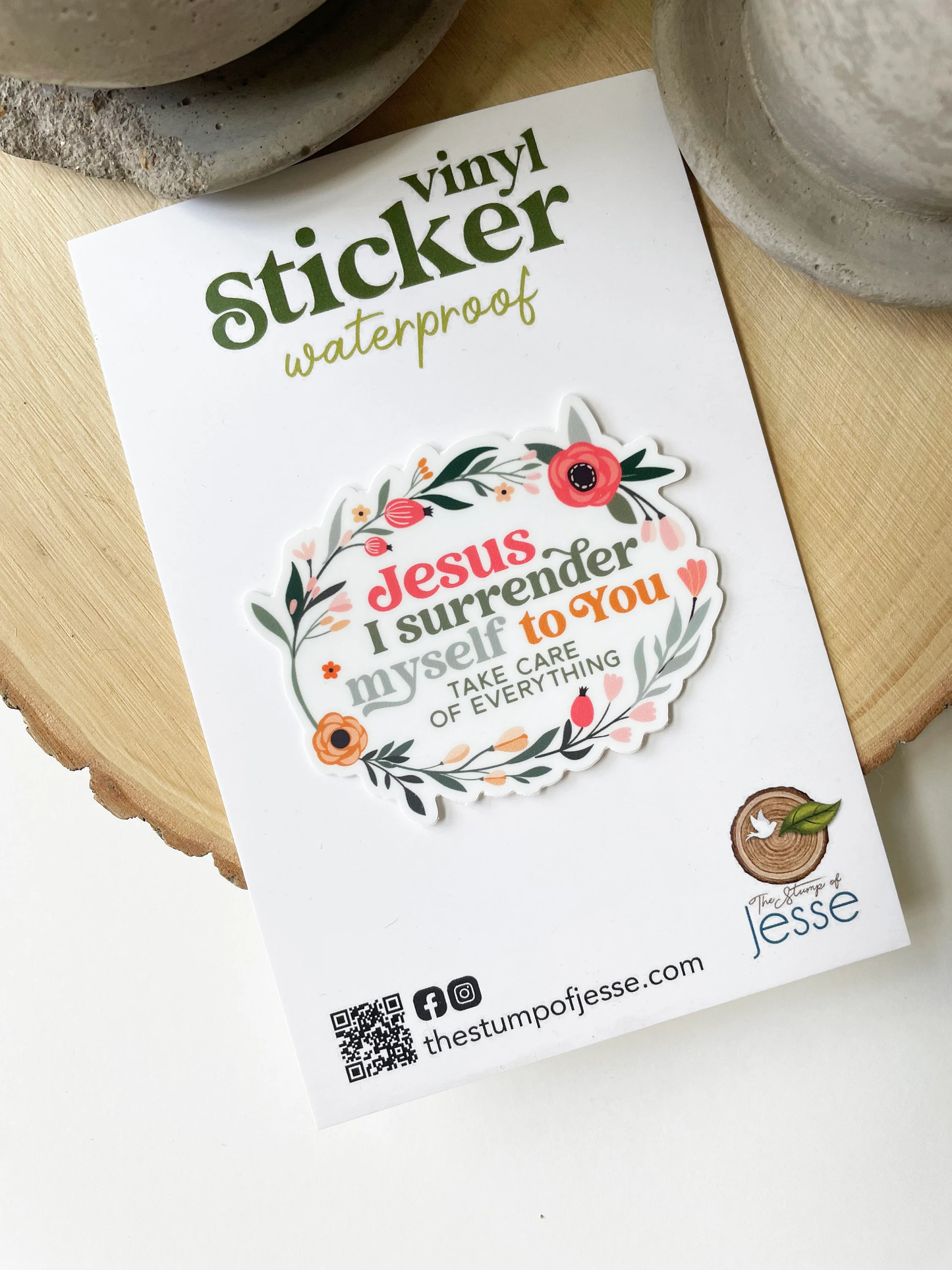 Vinyl sticker with floral design and text on a white card, placed on a wooden surface.